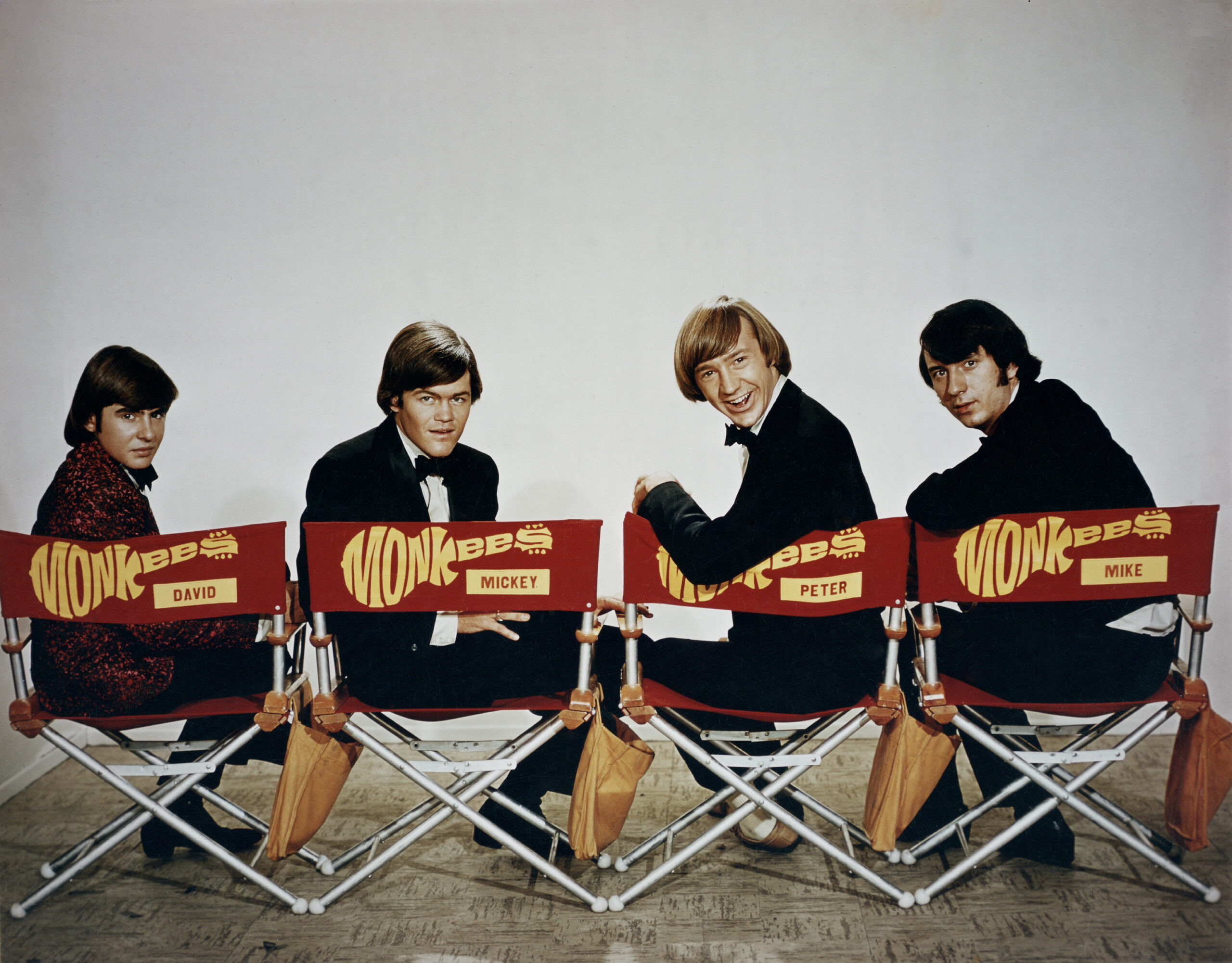 The Monkees sitting in directors chairs/ from left to right: Davy Jones, Micky Dolenz, Peter Tork, Mike Nesmith