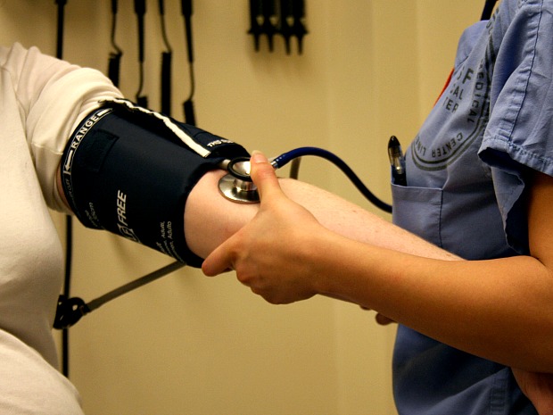 A health care provide takes a patient's blood pressure