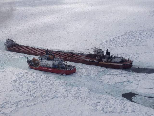 The Coast Guard Cutter Mackinaw escorting a barge through ice fields on Lake Superior