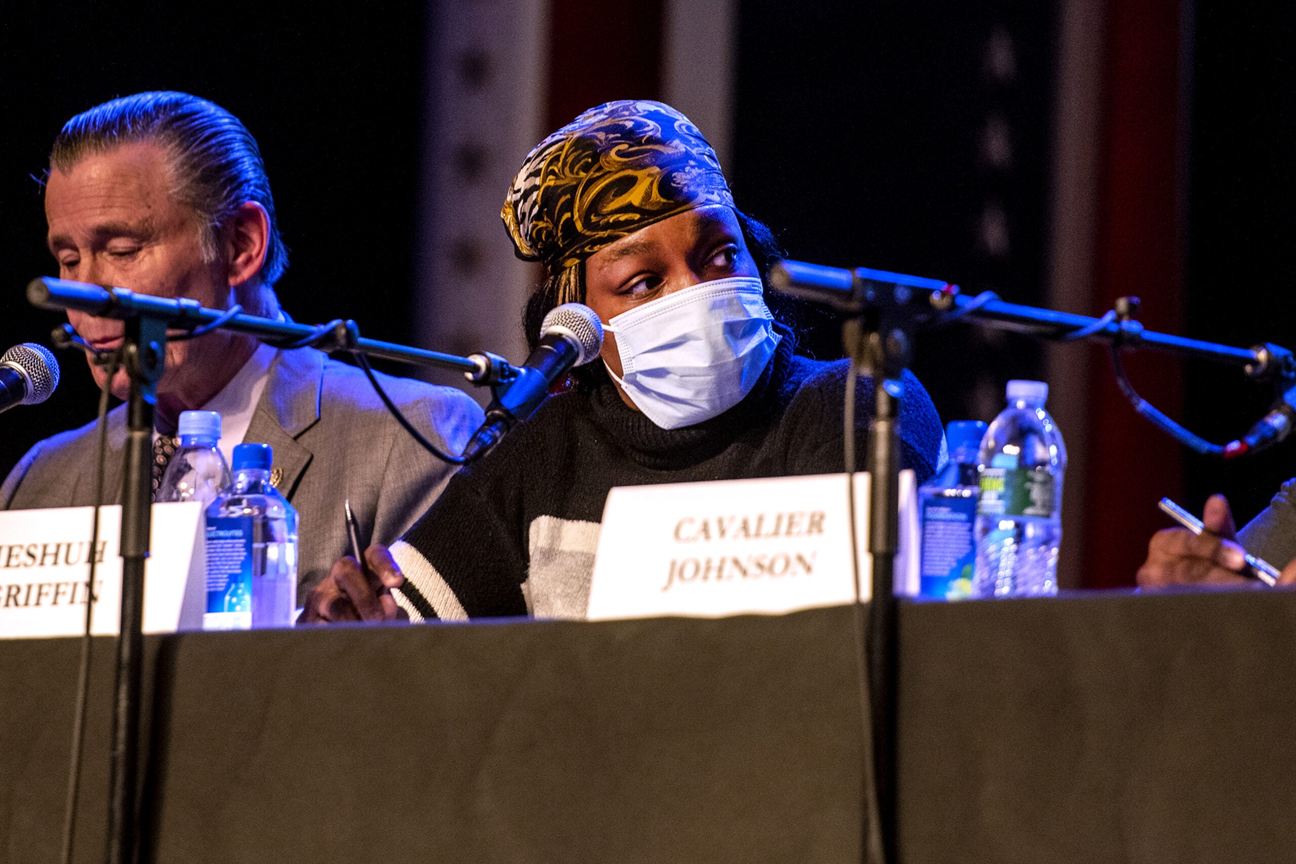 Ieshuh Griffin wears a face mask as she sits at a table with fellow candidates.