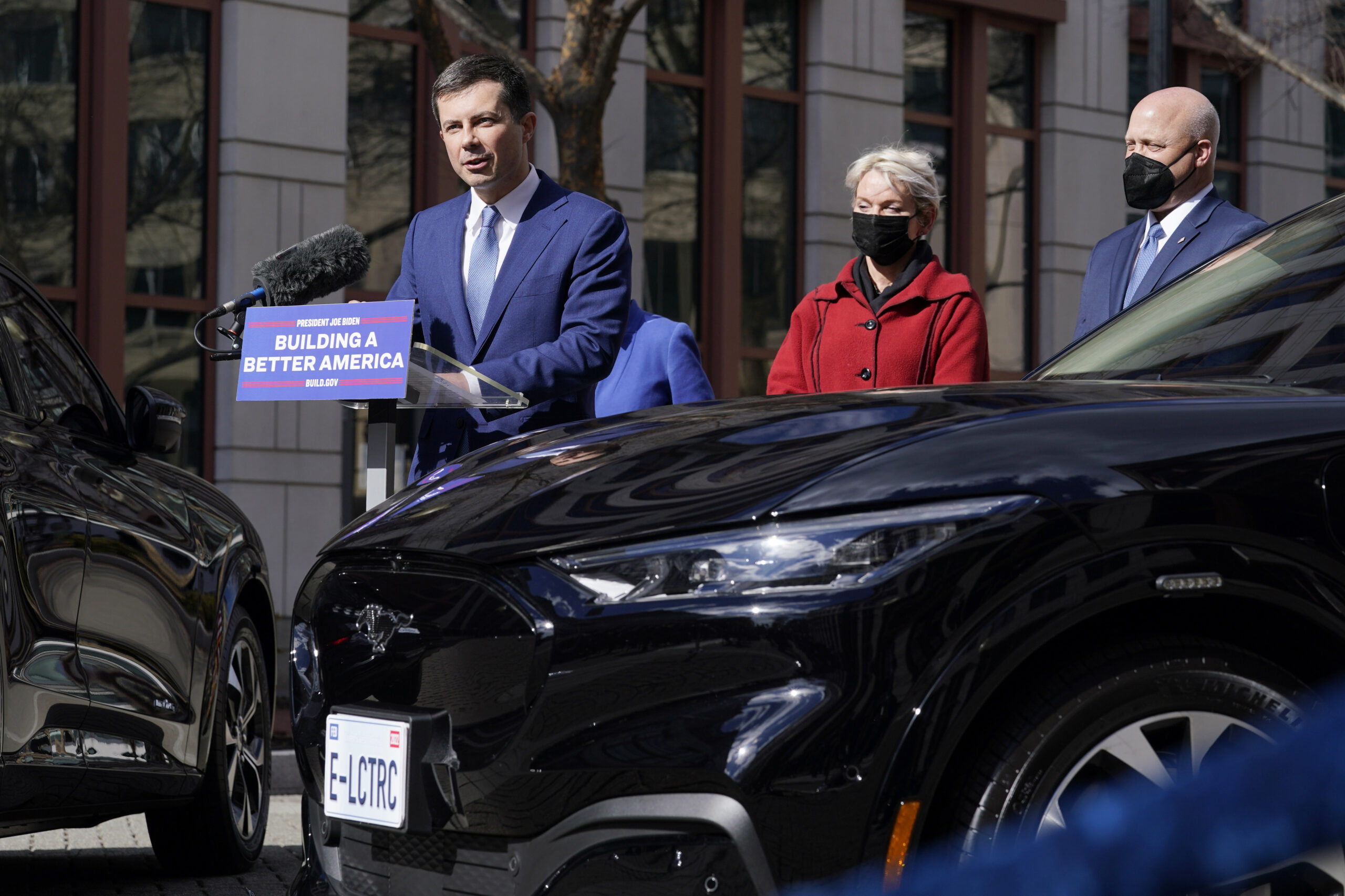 Transportation Secretary Pete Buttigieg, left, speaks during an event at the Transportation Department in Washington