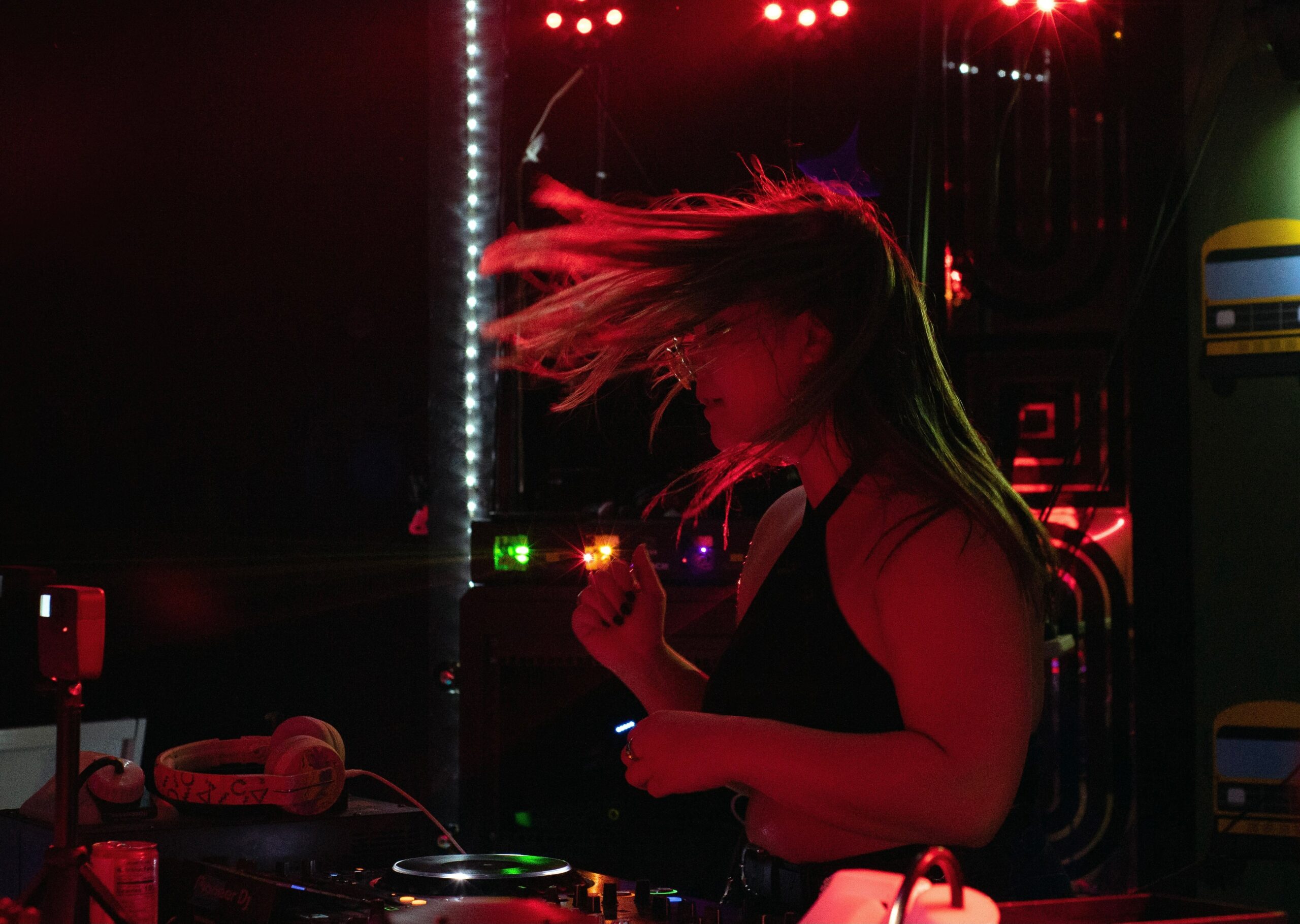 Claire DeRosa dances behind a DJ table.