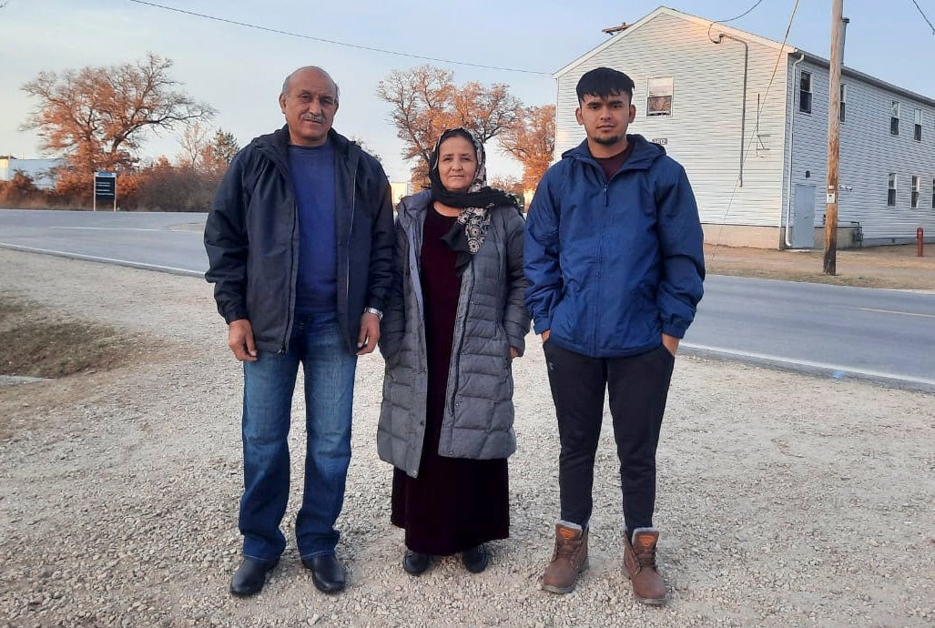 A father, mother and their son stand side by side at the Fort McCoy base