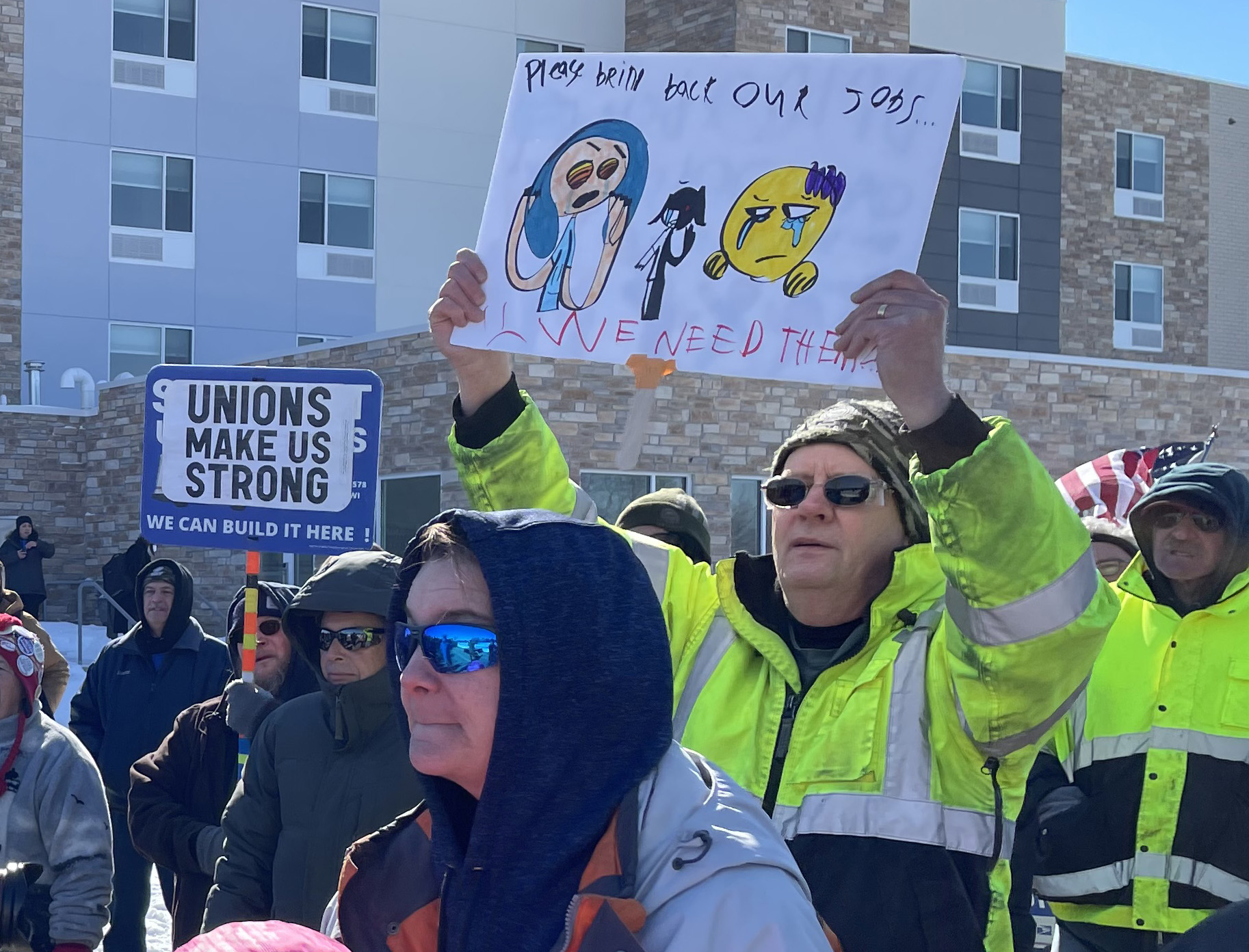 United Auto Workers member John Stanchik holds a sign made by his 9-year-old daughter, Reanlyn, at a rally calling on Oshkosh Defense to locate 1,000 new manufacturing jobs in Wisconsin. 