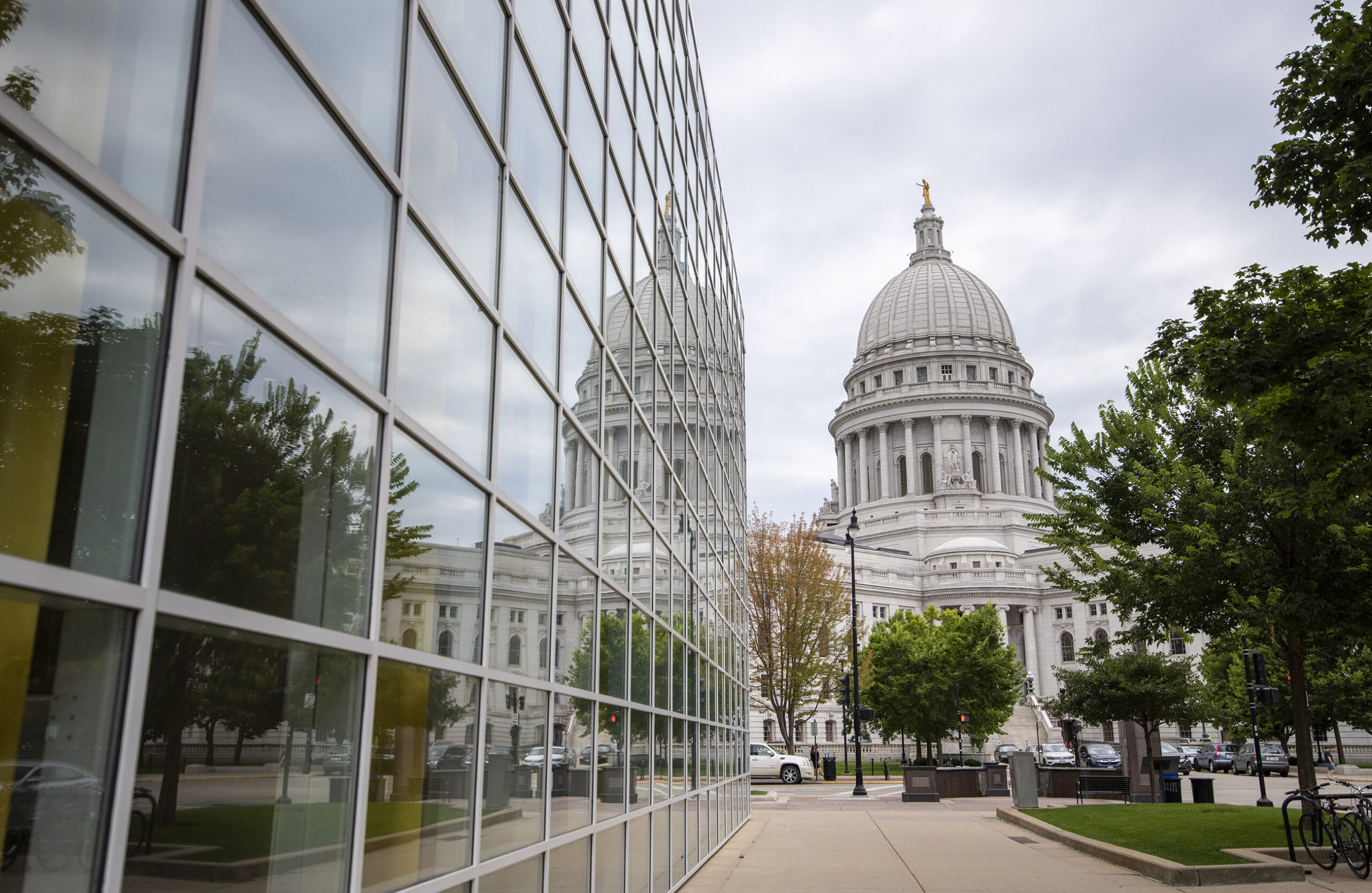 The Wisconsin State Capitol reflects on the glass walls of the US Bank Plaza