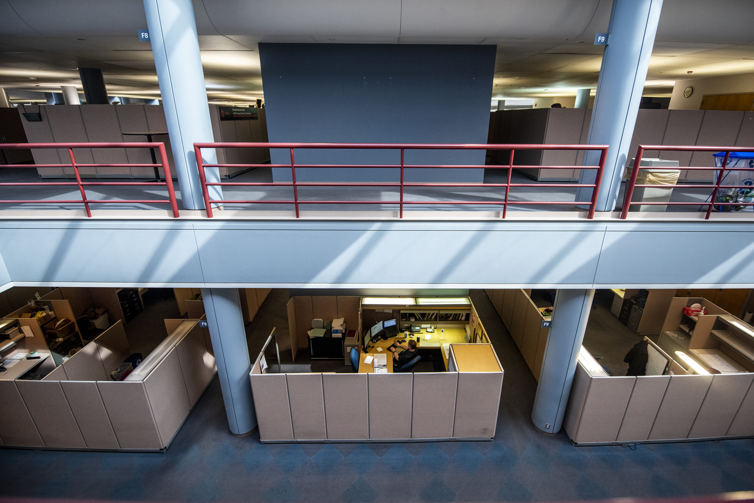 Three cubicles can be seen from an upper floor.
