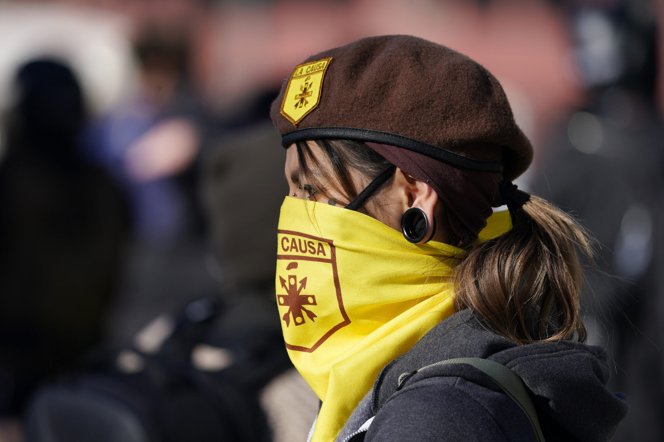 A member of the Brown Berets is shown from the side with a yellow face covering