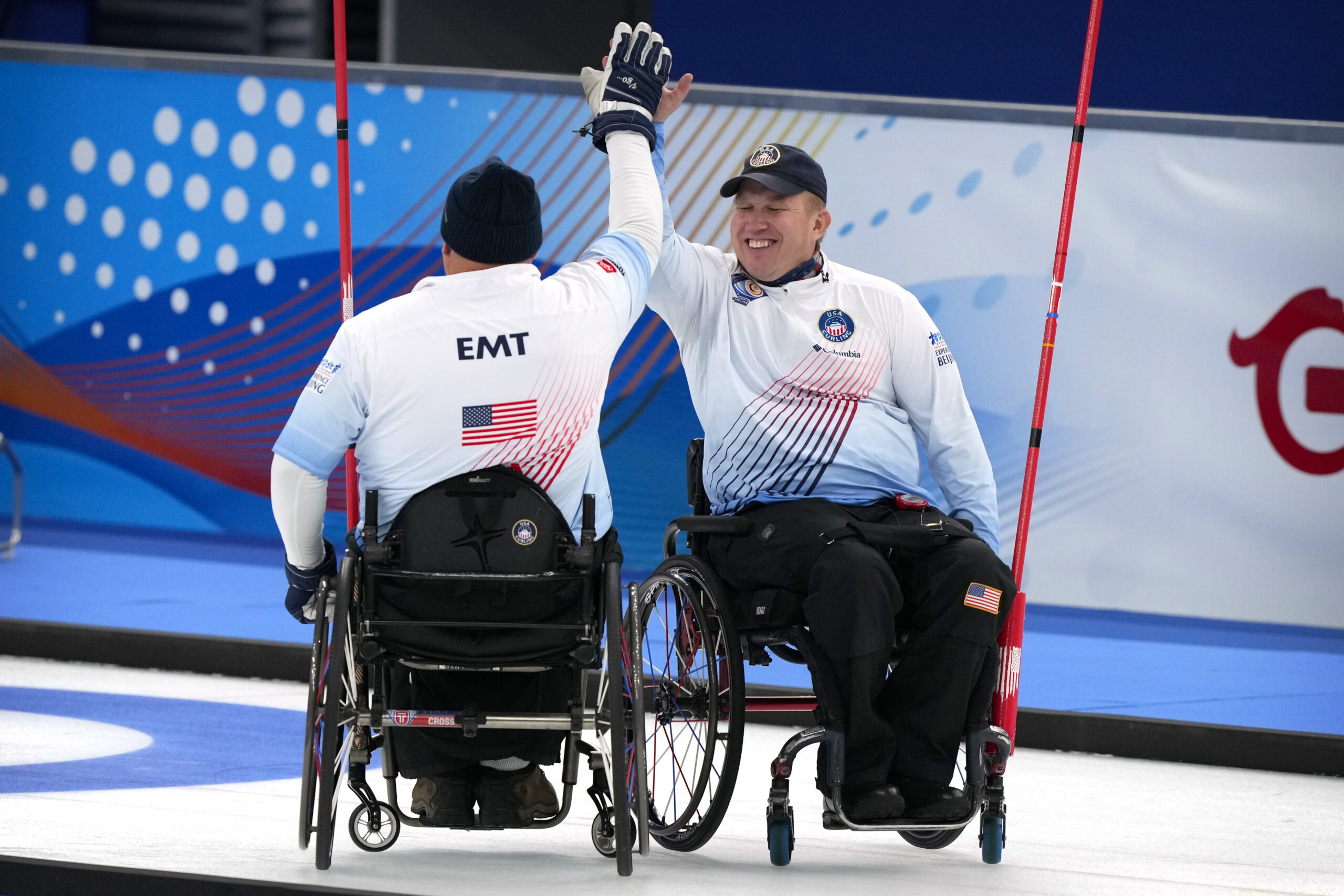 Two Paralympic curlers high five