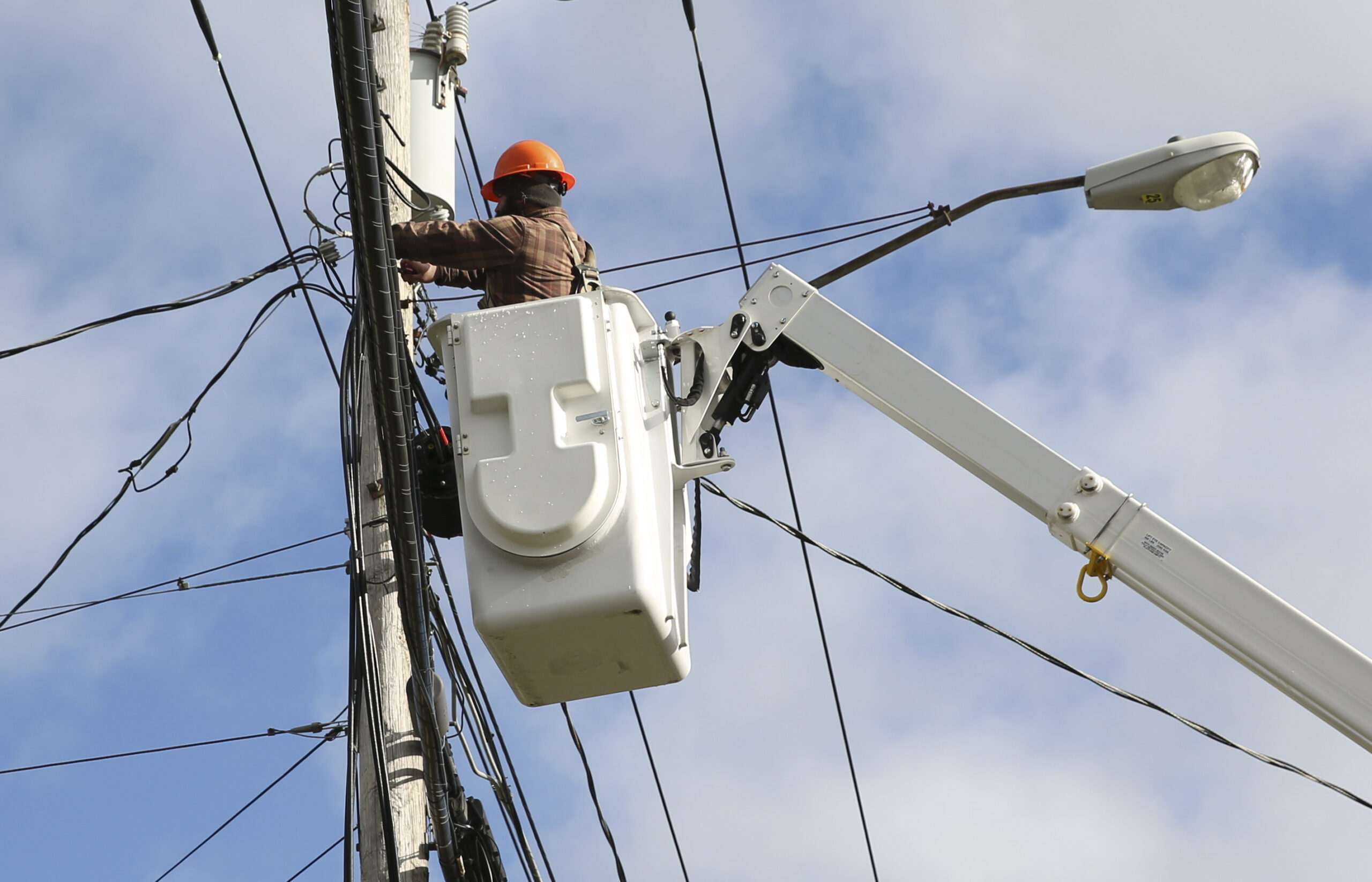 A telecommunications crew member helps extend broadband service.