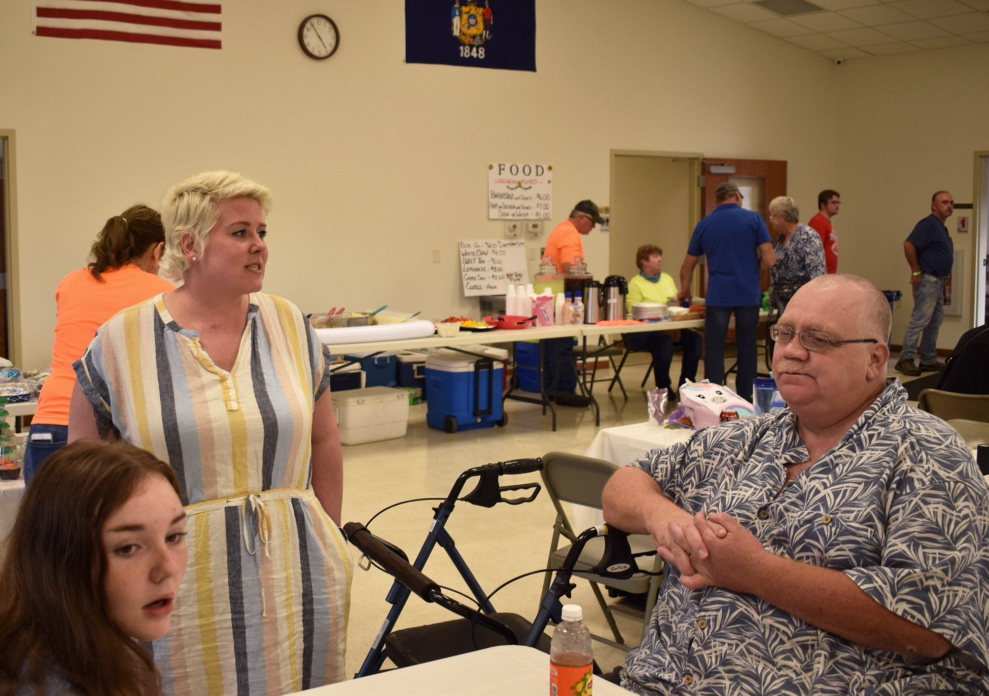 Betsy Bloch, second from left, speaks with family members at a community benefit for her family in Merrill