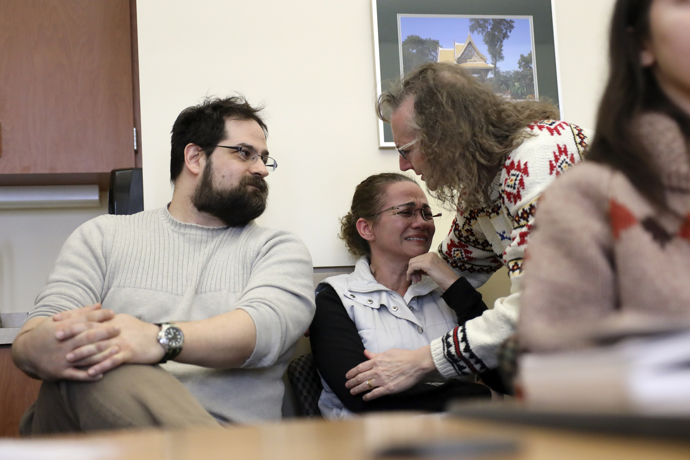 Maria Alice Lima Freitas crying and being comforted at a Madison Area Lyme Support Group meeting