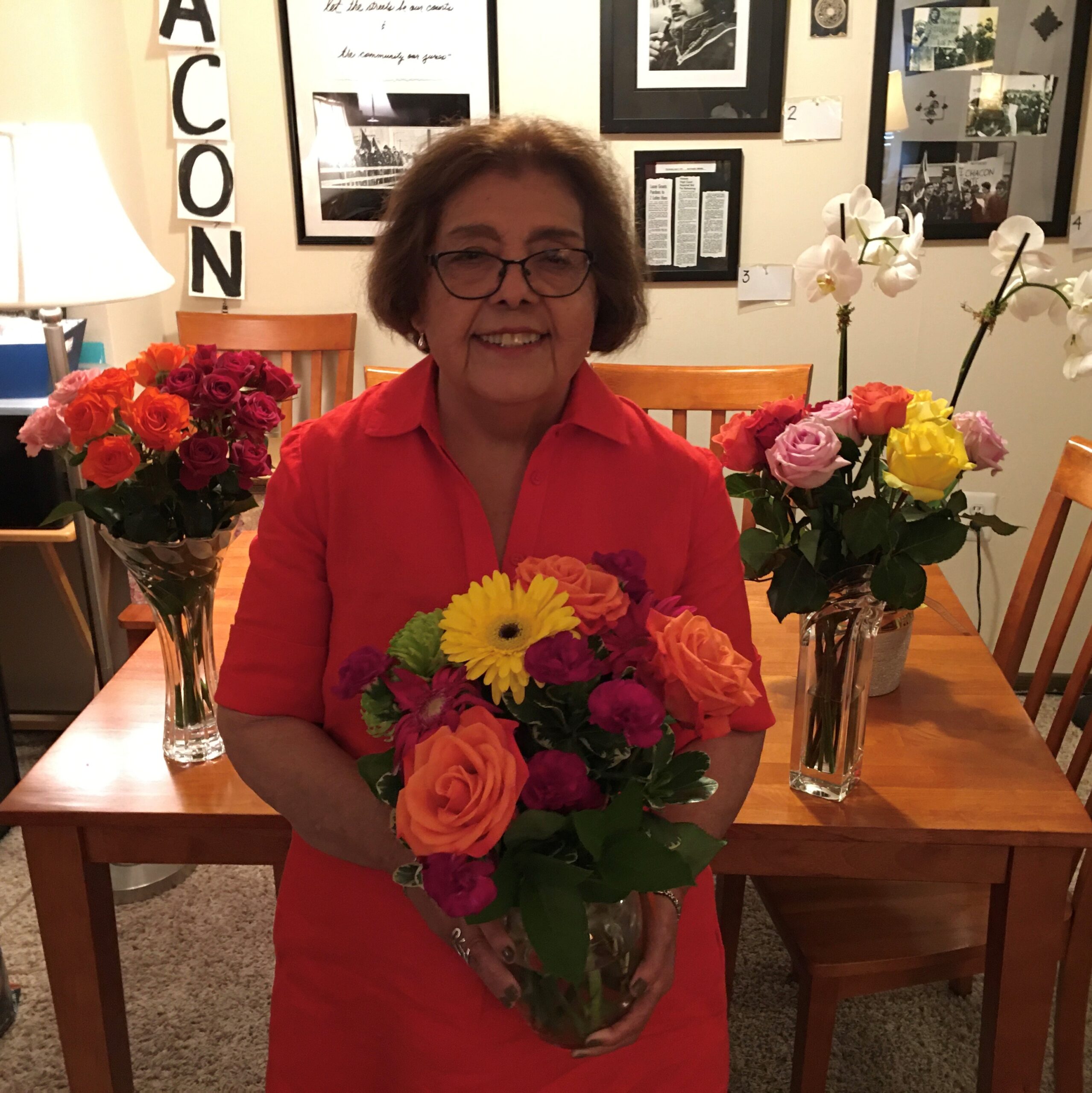 Maria Cruz stands smiling while holding flowers