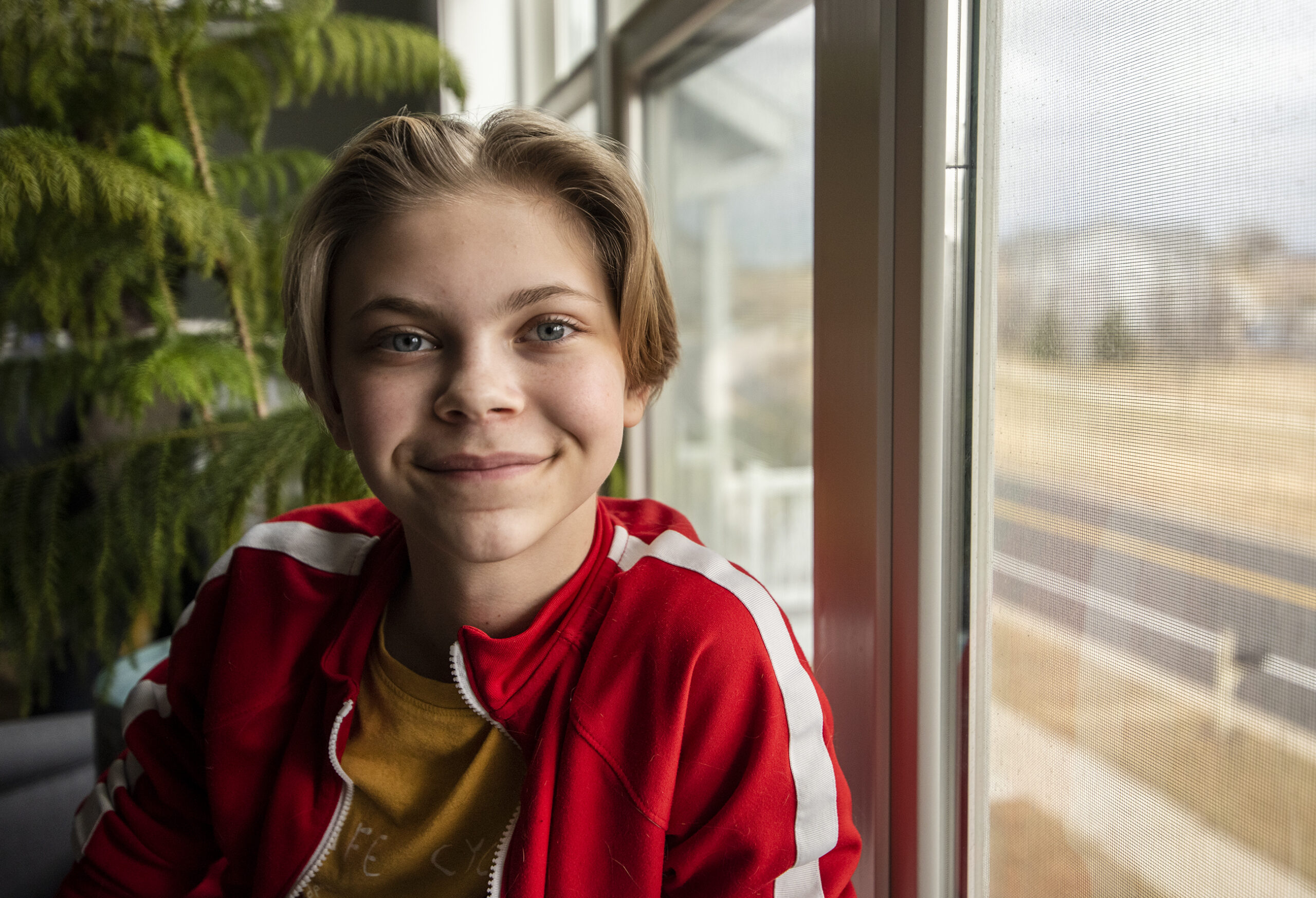 Bailey Mosling smiles while sitting next to a window.