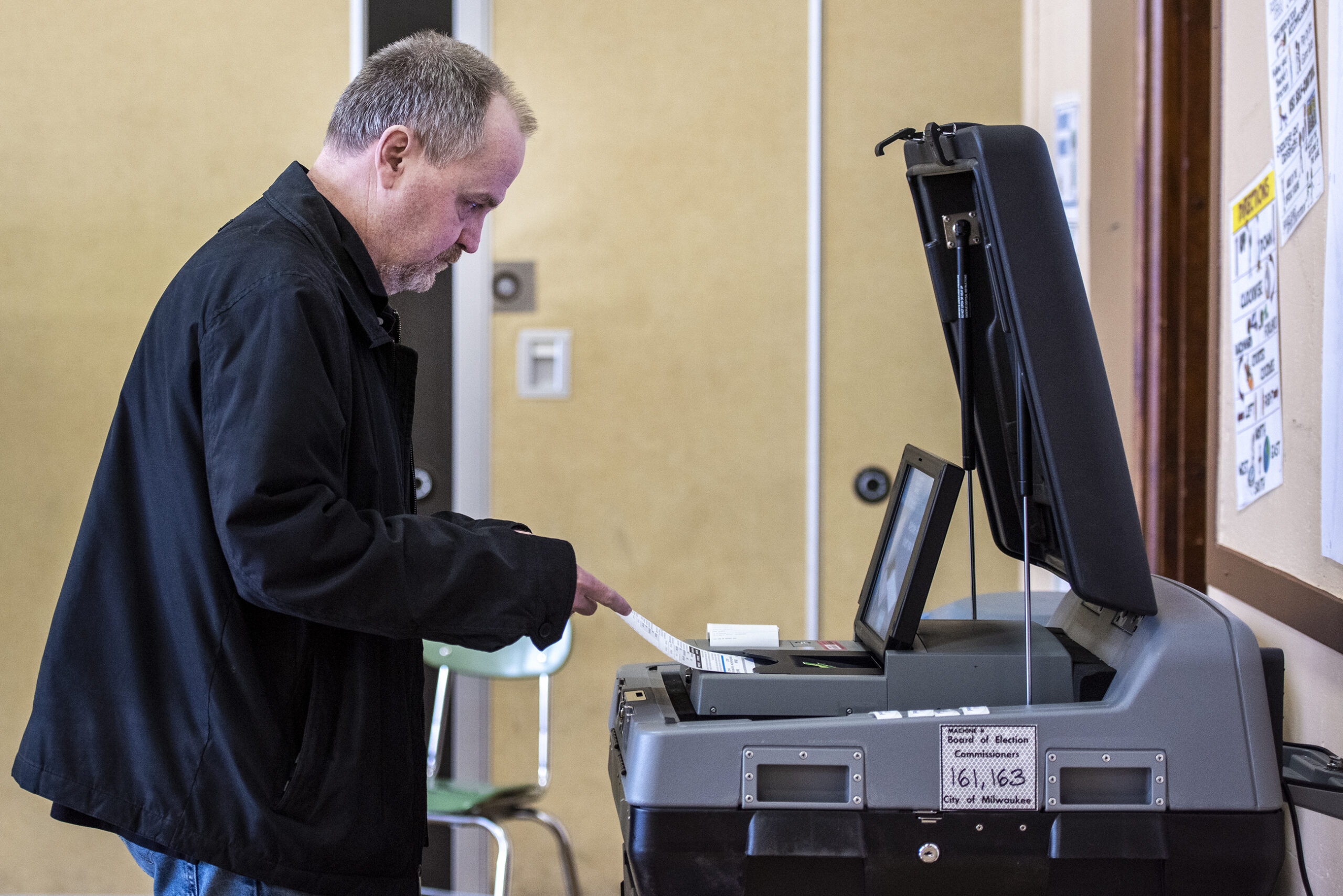 A voter puts his ballot into a machine at a polling location.