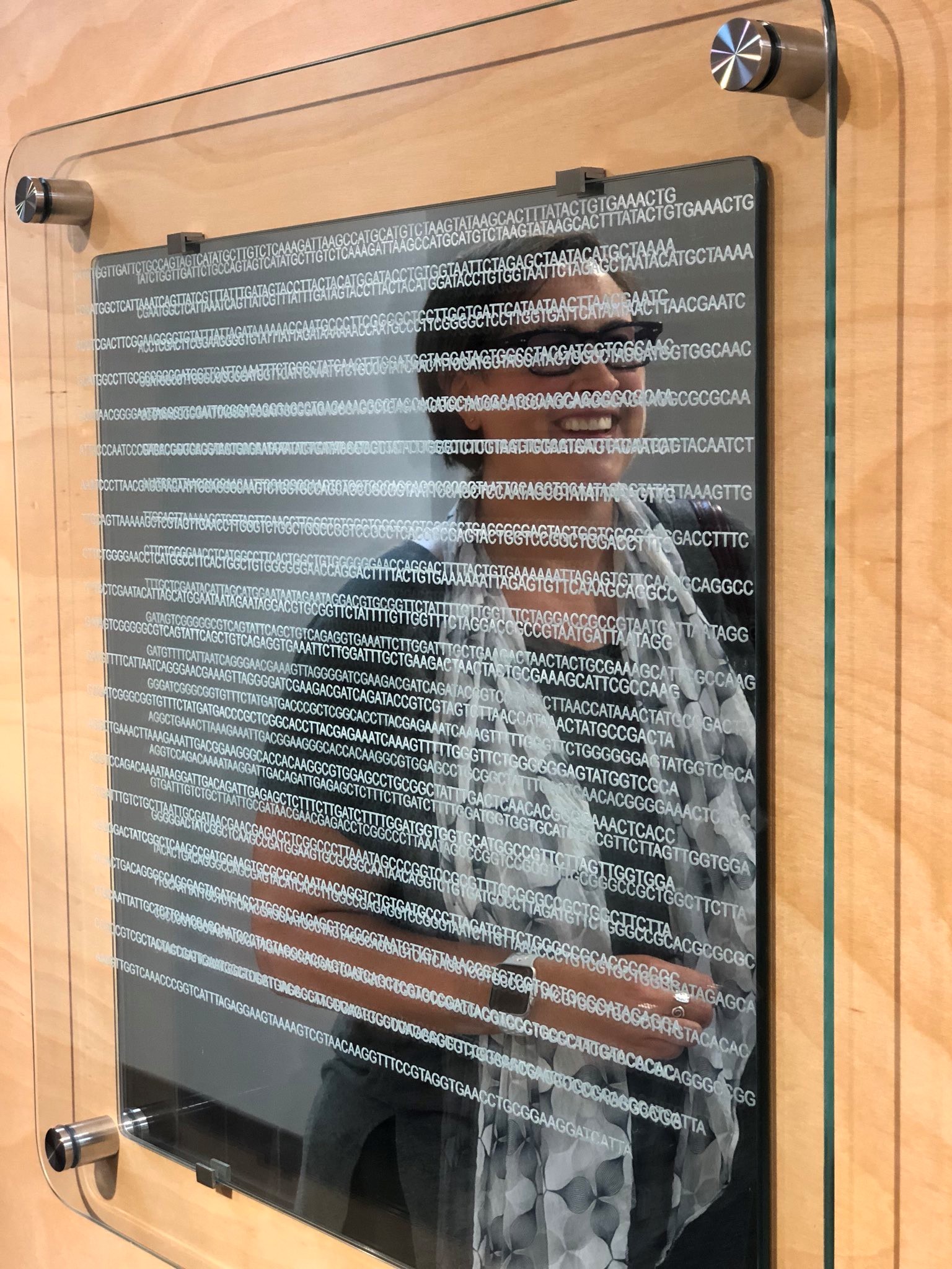 A reflection of Ahna Skop sits on a piece of art that came through science