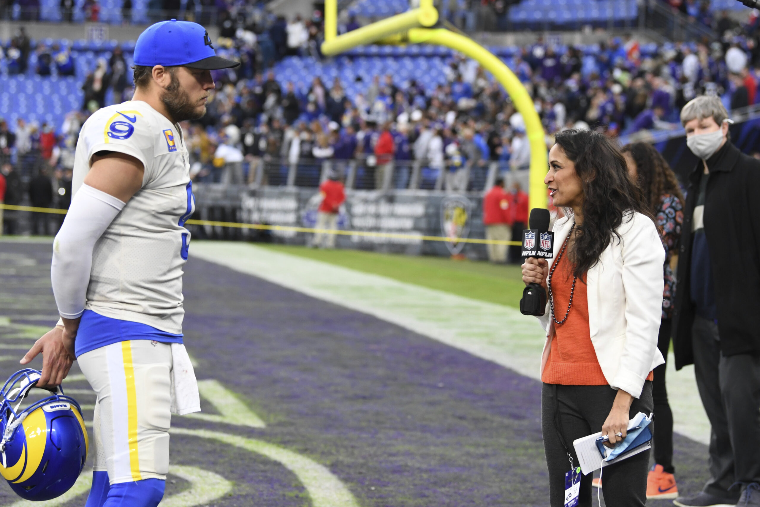 Reporter interviews football player on the sidelines