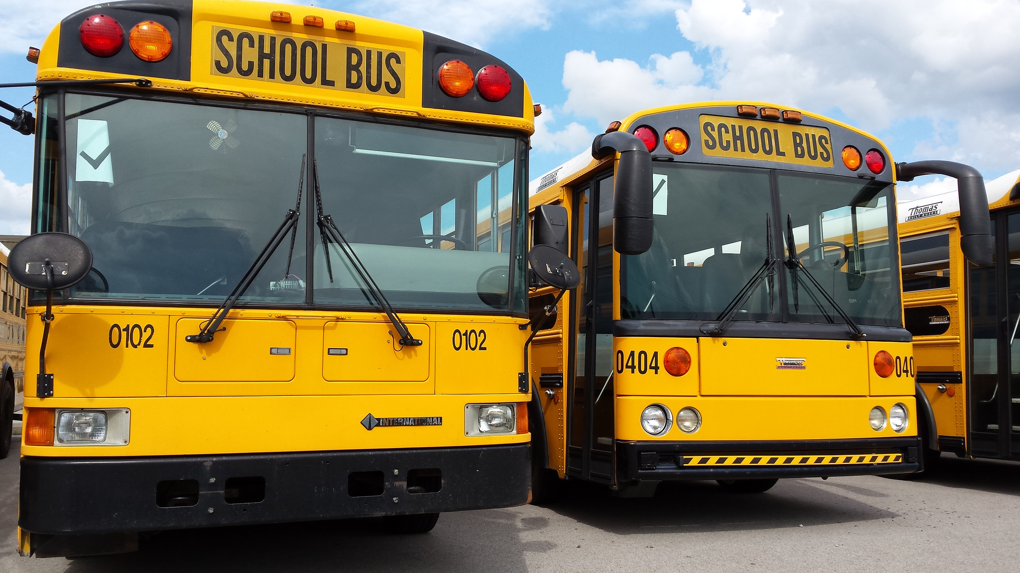 Two school buses sit in a parking lot.