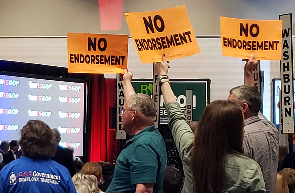 Republican activists hold up signs encouraging no endorsement of a GOP candidate for governor