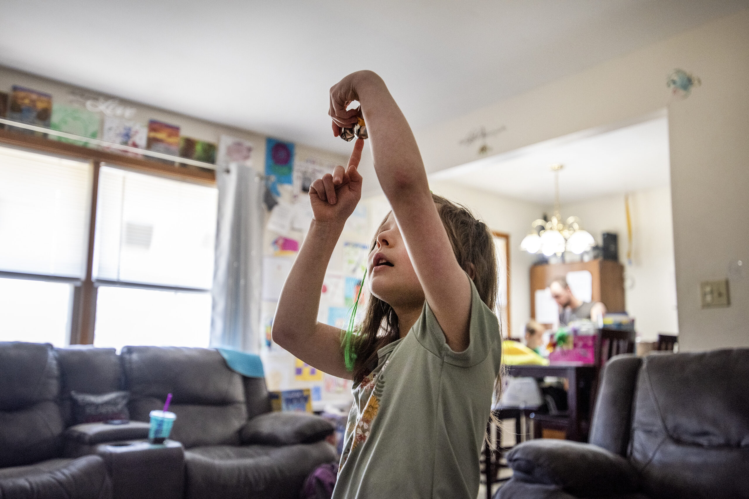 A student dances in the middle of the living room.