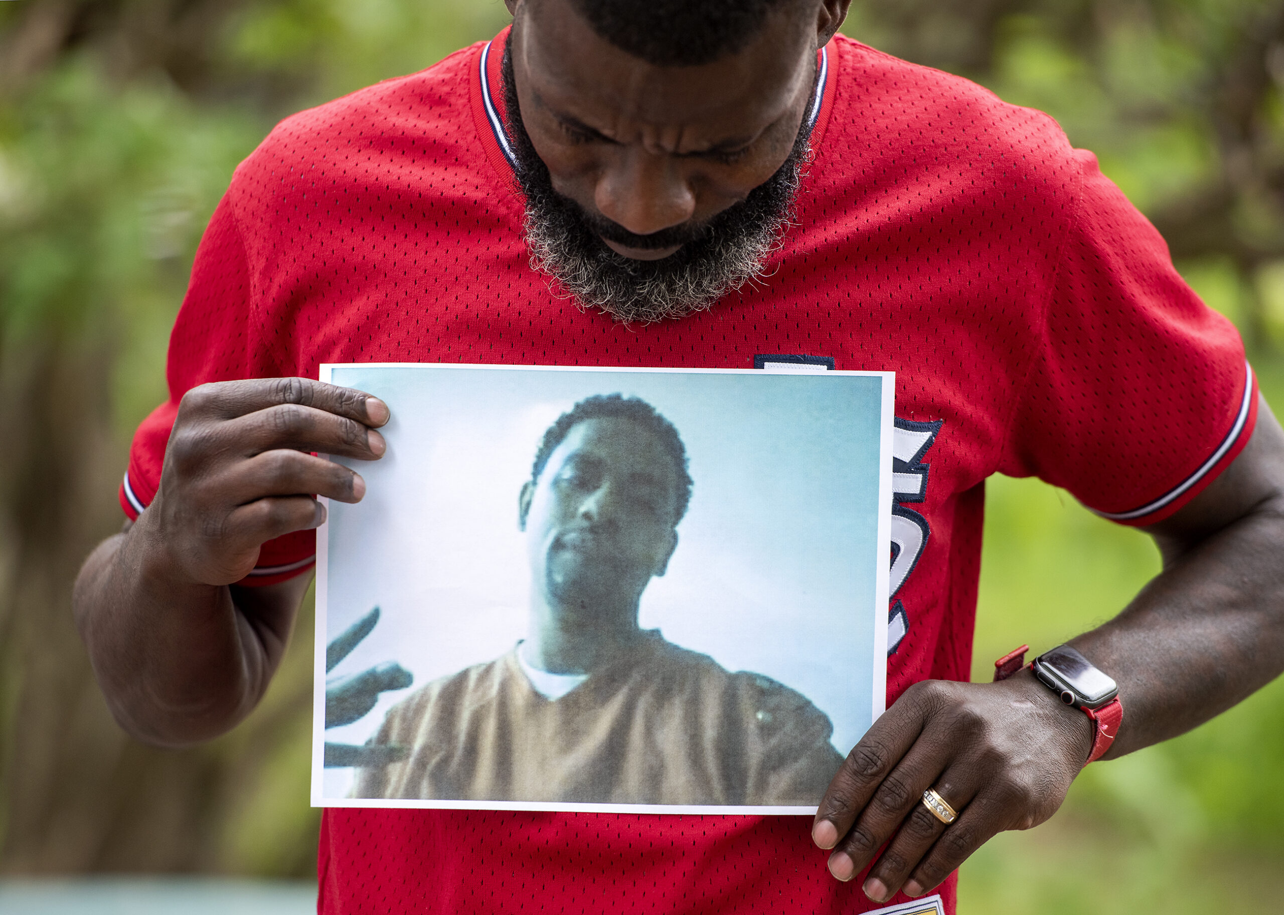 Segdrick Farley looks down at a printed photo of his brother, Alvin L. Simmons