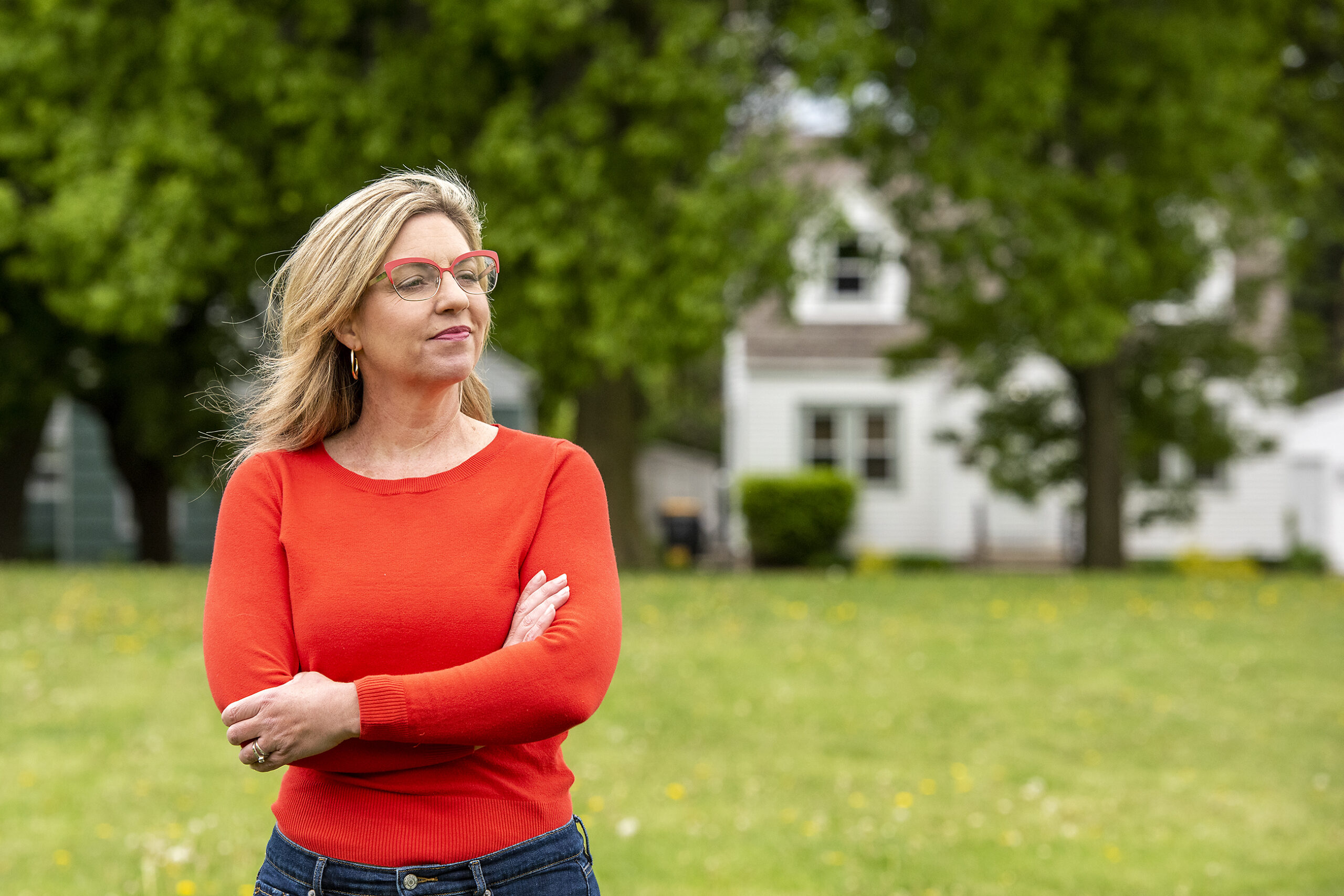 Rep. Robyn Vining wears a red shirt as she stands in a neighborhood park.