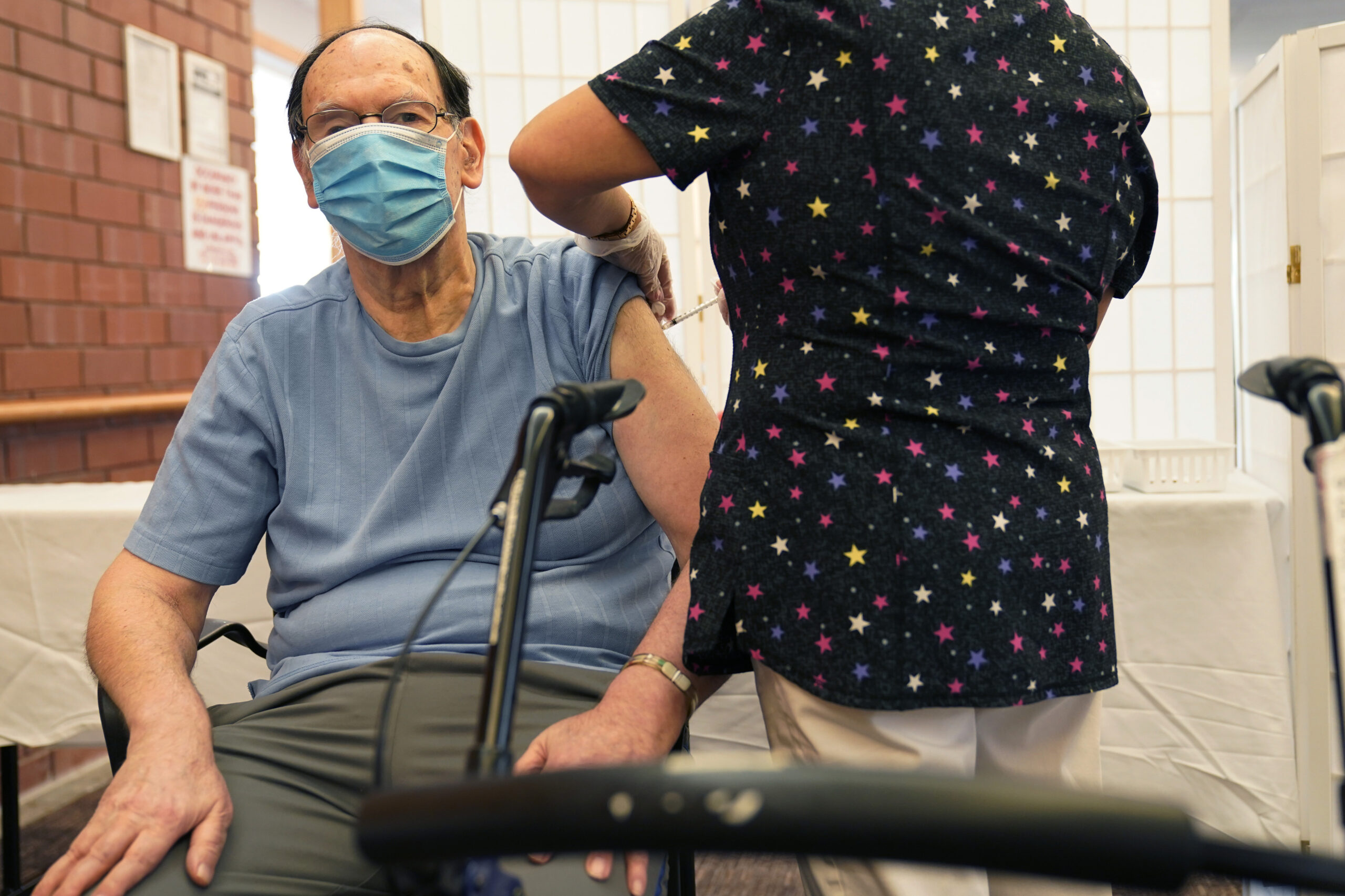 Marvin Marcus, 79, a resident at the Hebrew Home at Riverdale, receives a COVID-19 booster shot.