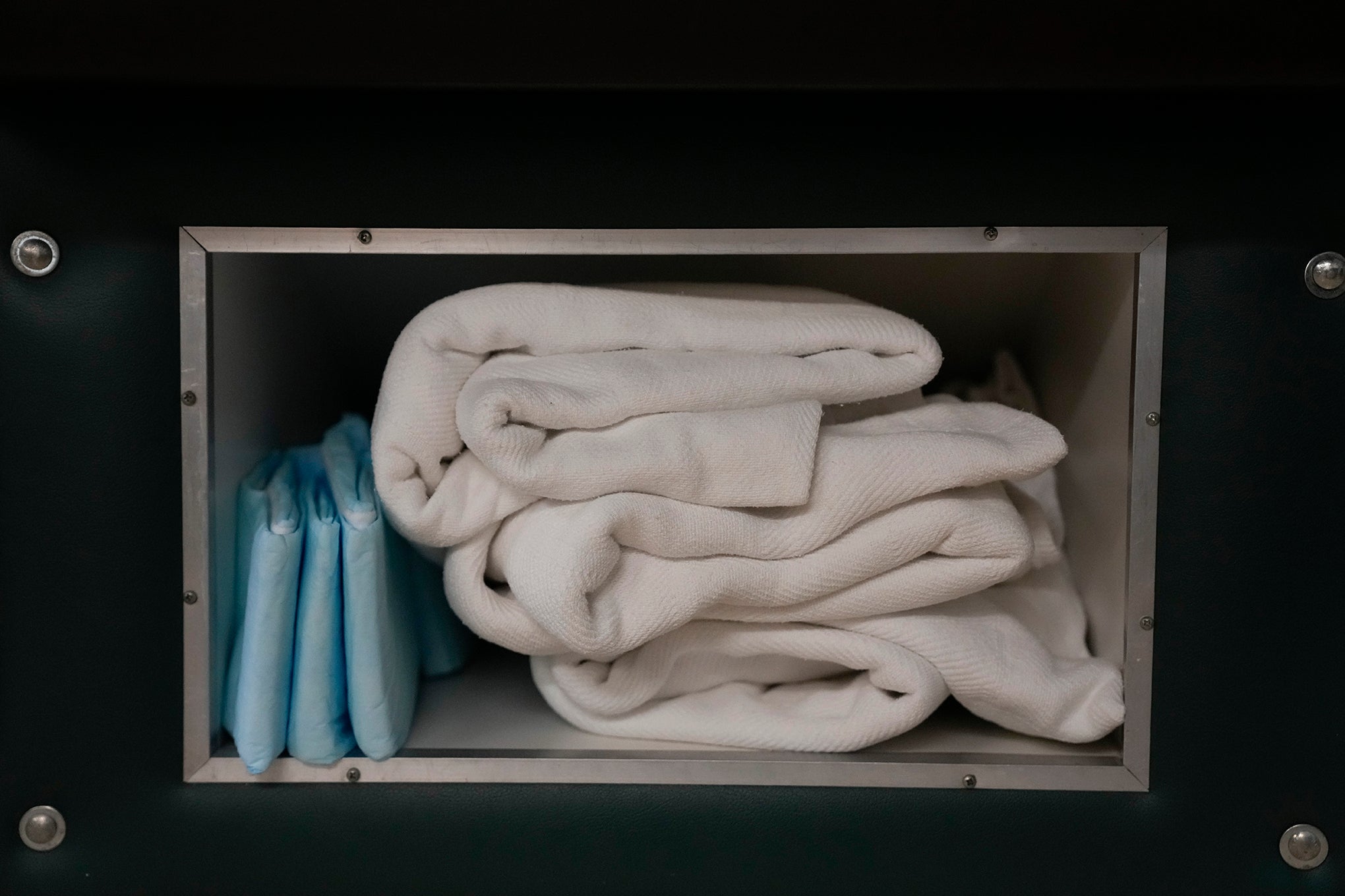 Extra blankets and pads are stored under a bed where women getting abortions