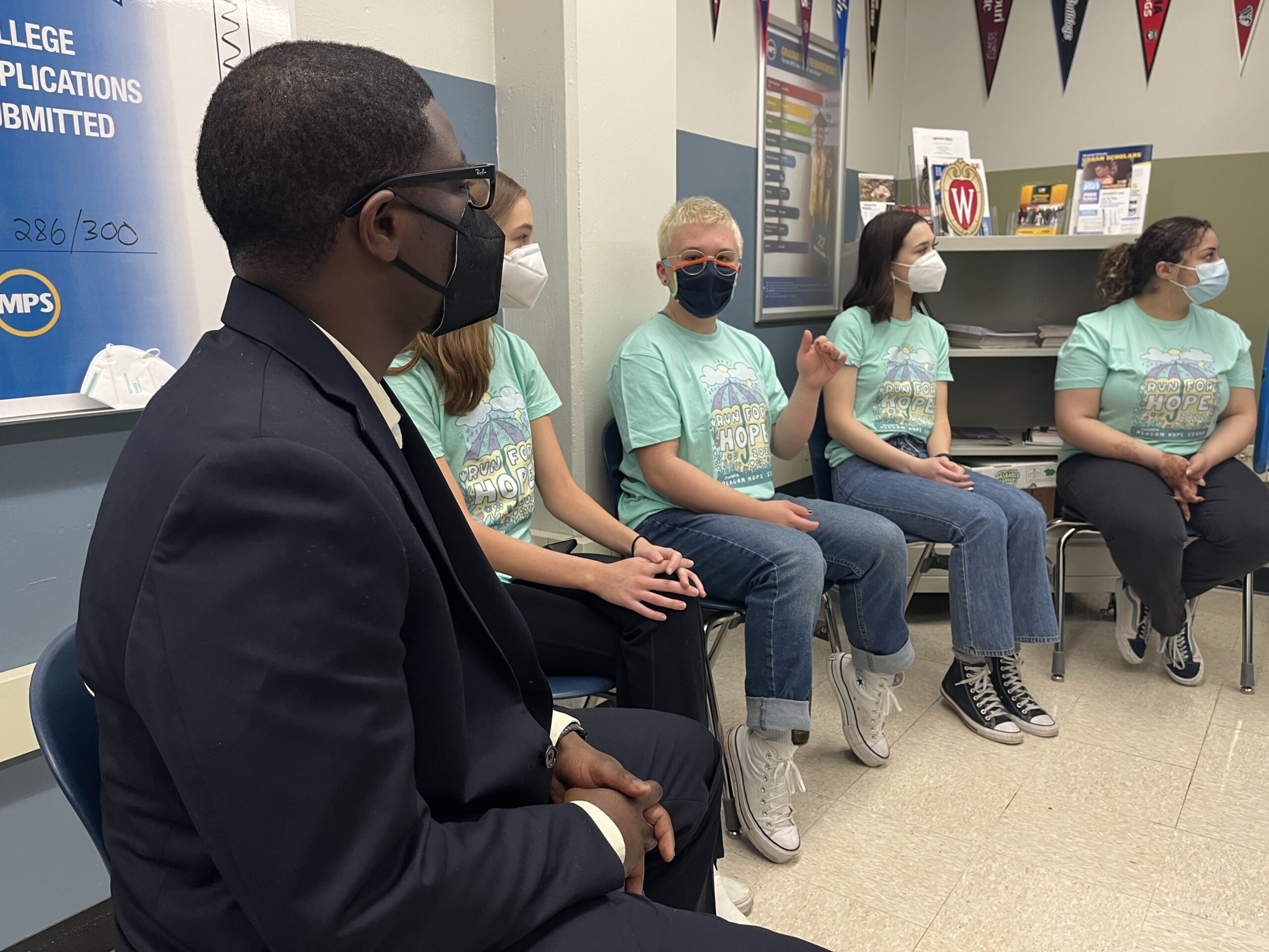 David Crowley faces four students at Ronald Reagan High School, all wearing Hope Squad T-shirts, as they explain their peer mental health network.