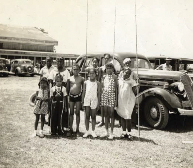 A group of people pose for a photo outside of the Lake Ivanhoe Pavilion