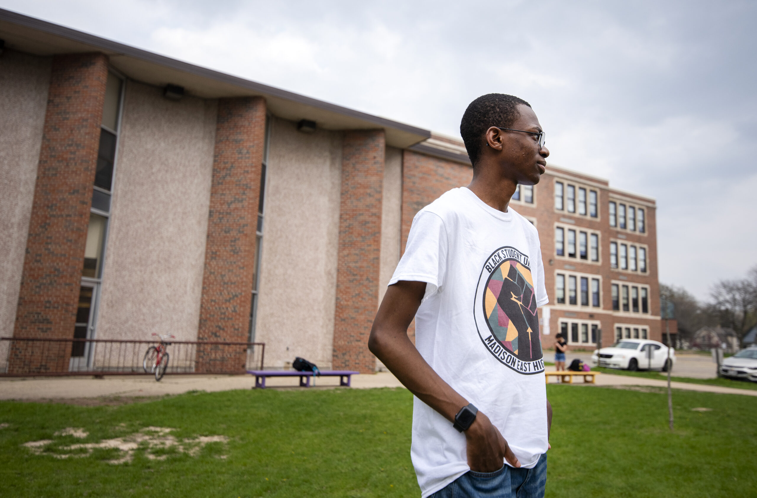 Gordon Allen looks to the side while standing in front of his school building.