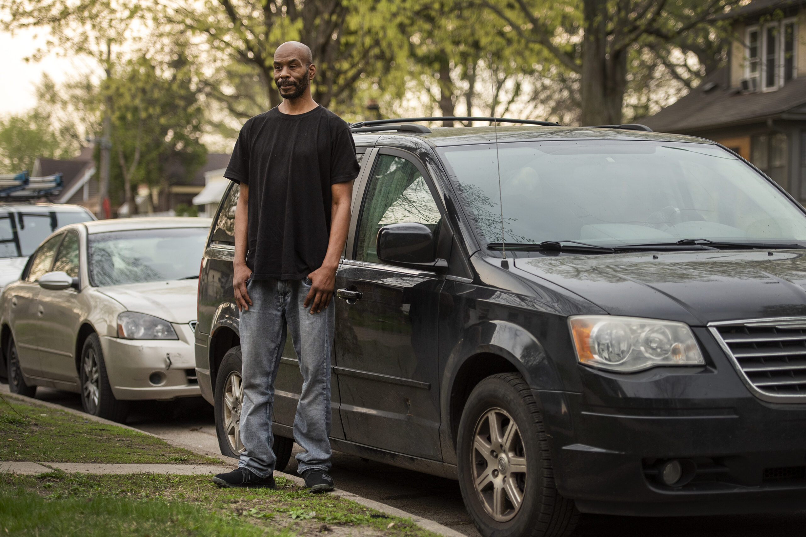 Clifford Skinner leans against a black van.