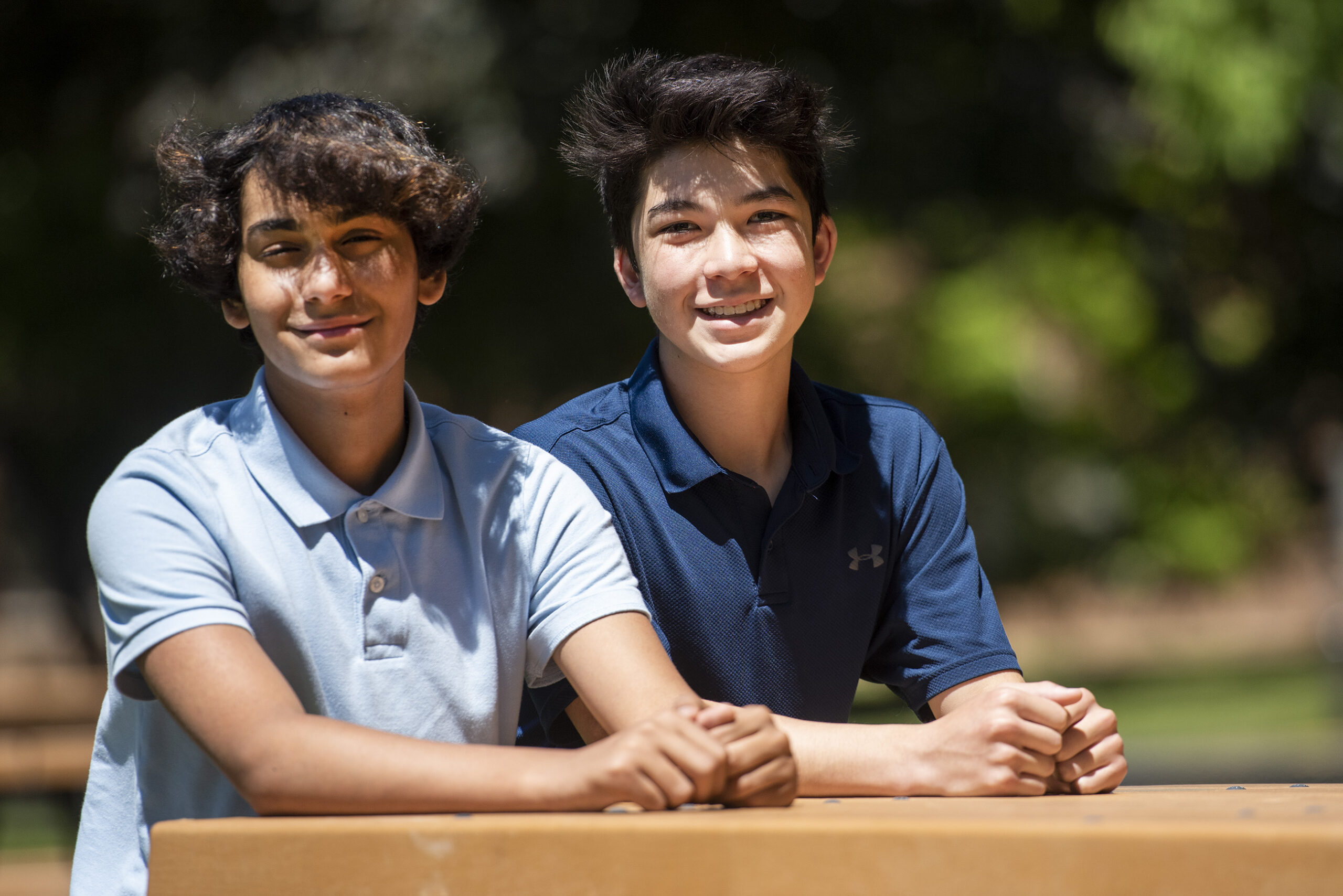 Veer Gokhale and Carson Tauscher sit outside at a picnic table.