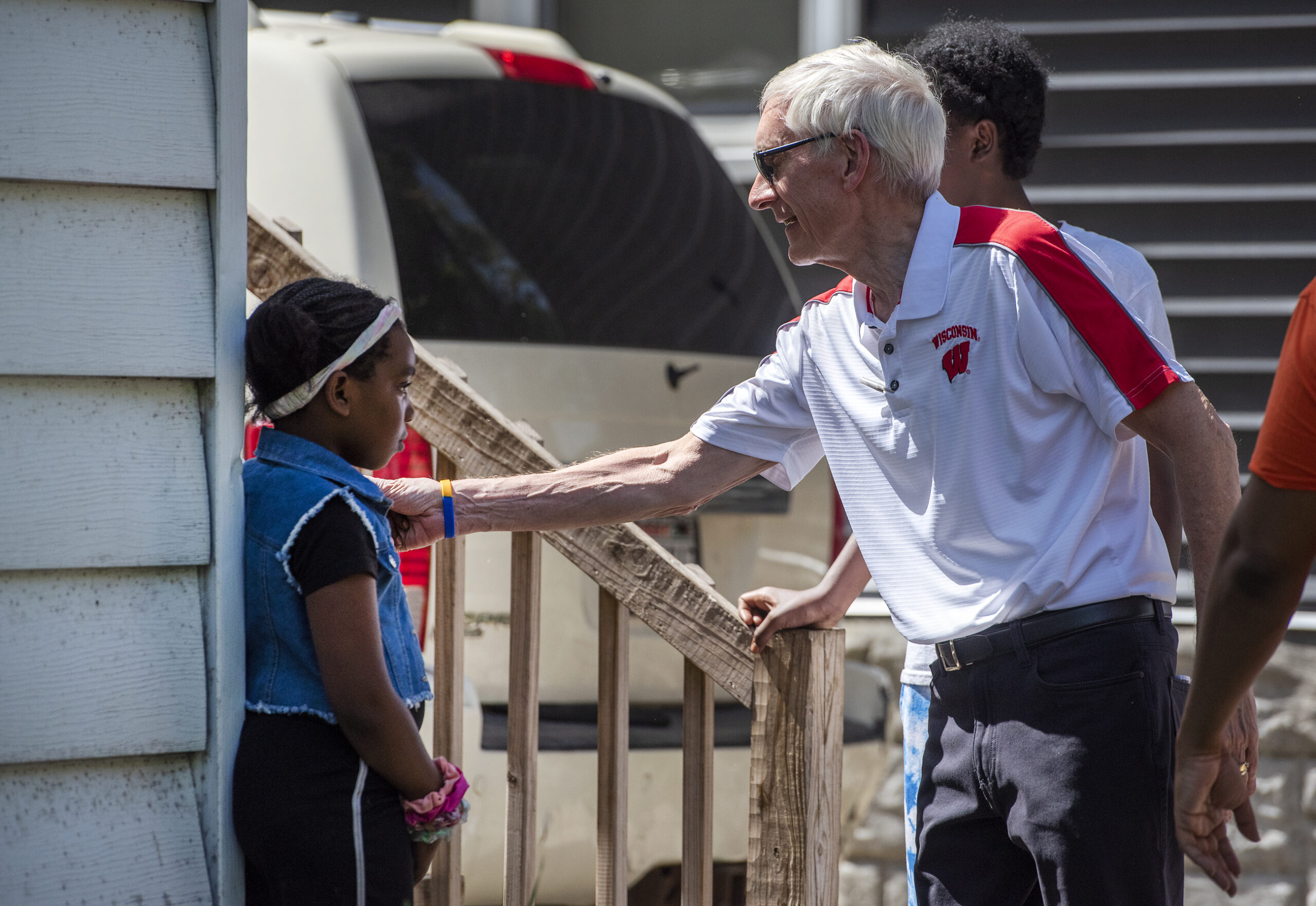 Gov. Tony Evers greets a child during a walk outside.