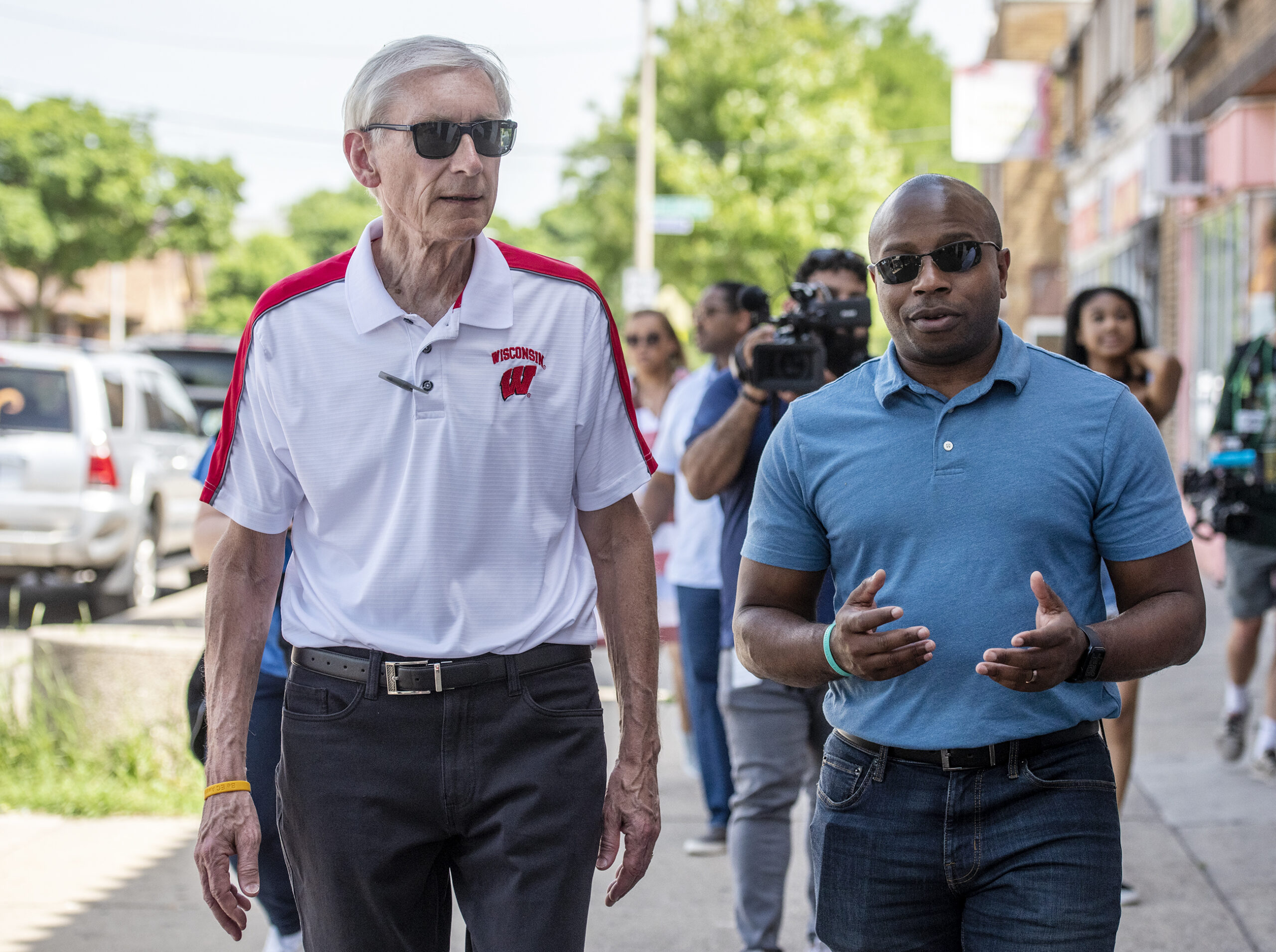 Gov. Tony Evers and Mayor Cavalier Johnson walk side-by-side on a sidewalk.