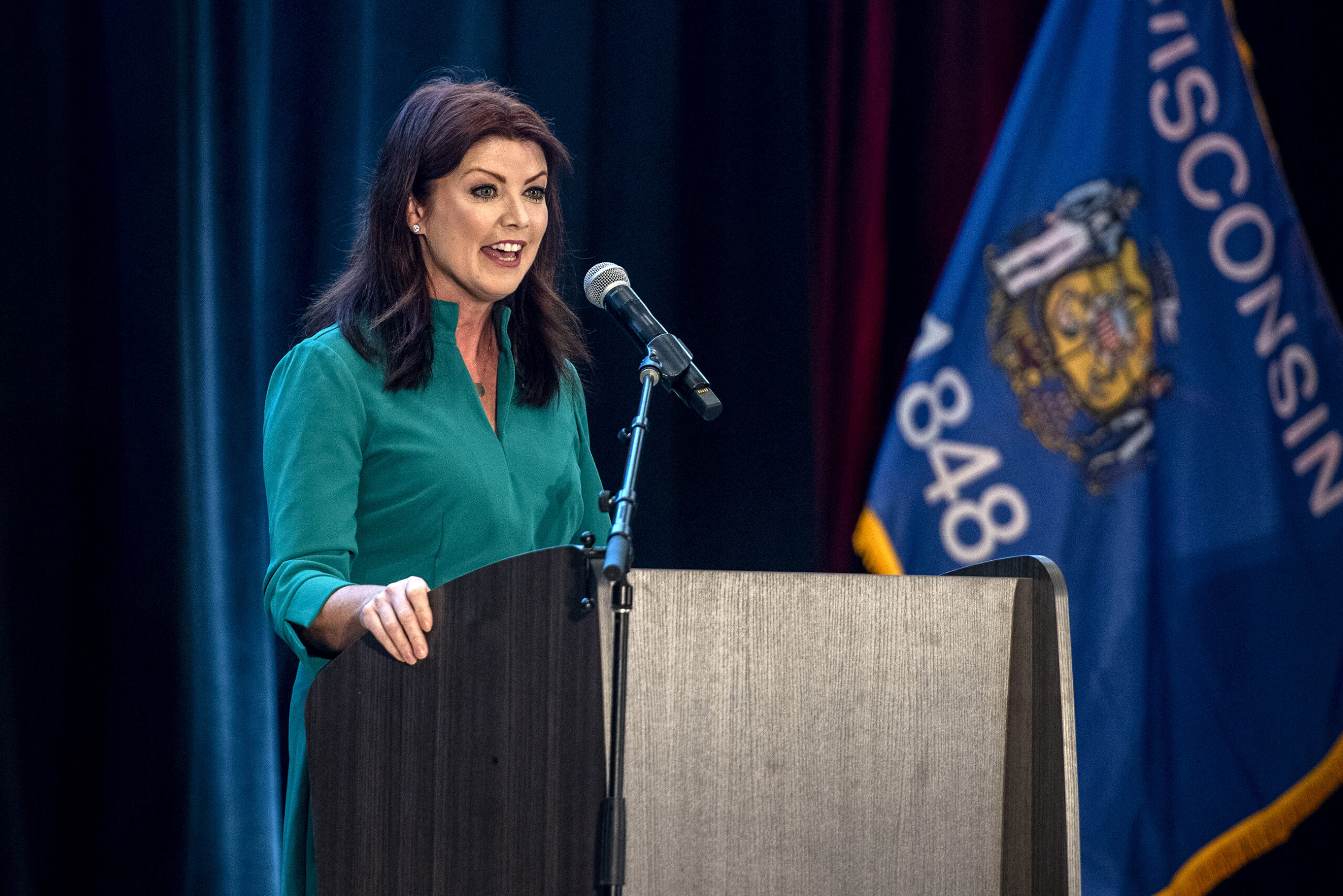 Rebecca Kleefisch speaks into a microphone on stage.