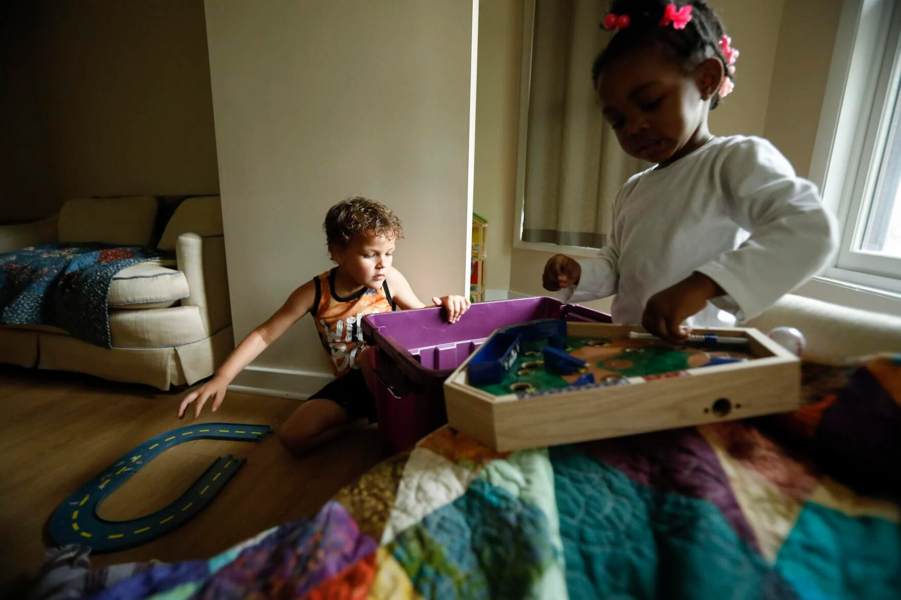 Two children play in the playroom of the Healing House