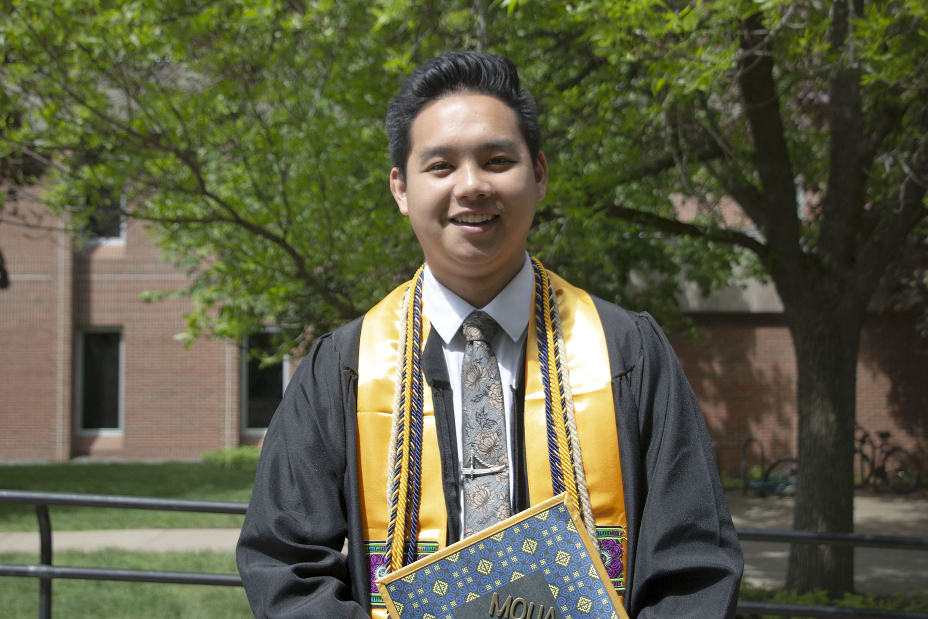 Meng Chamoua holds his diploma from UW-Eau Claire.