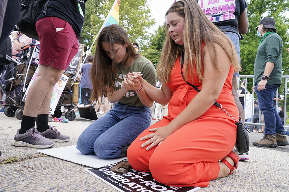 Anti-abortion activists Maggie Donica, 21, right, and Grace Rykaczewski, 21, left, pray following the Supreme Court's decision to overturn Roe v. Wade