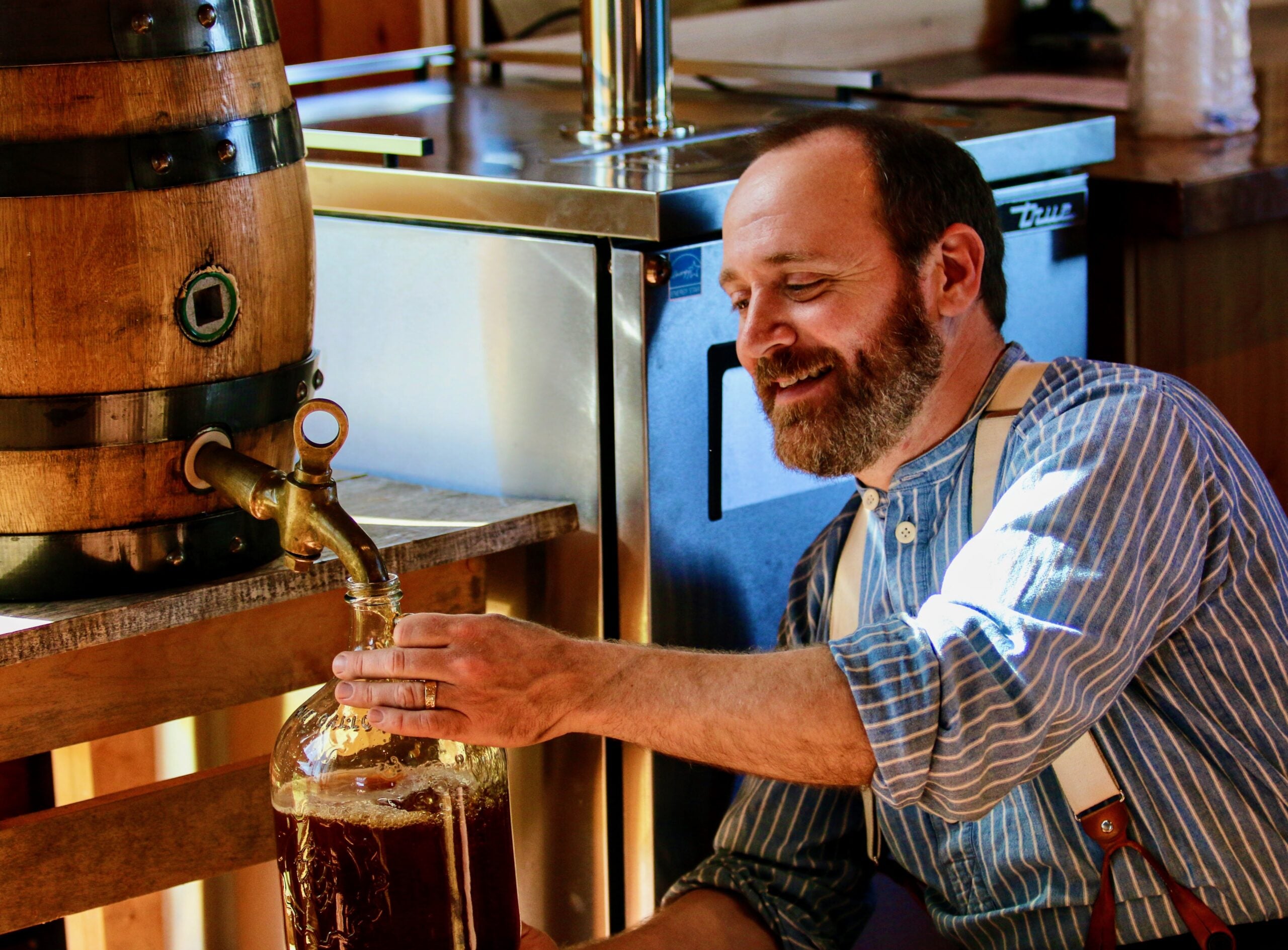 A man fills a bottle with beer at Old World Wisconsin