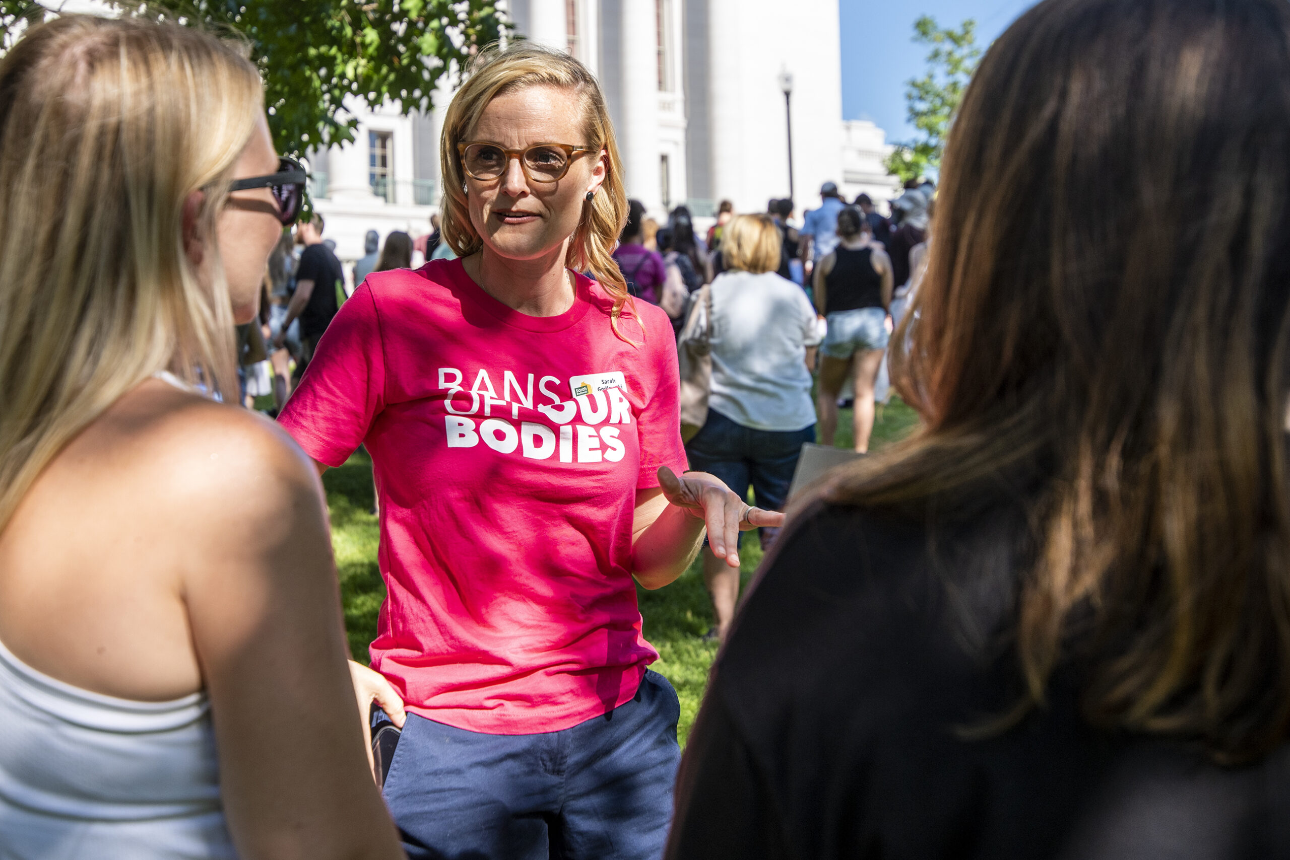 Sarah Godlewski wears a pink shirt that says 