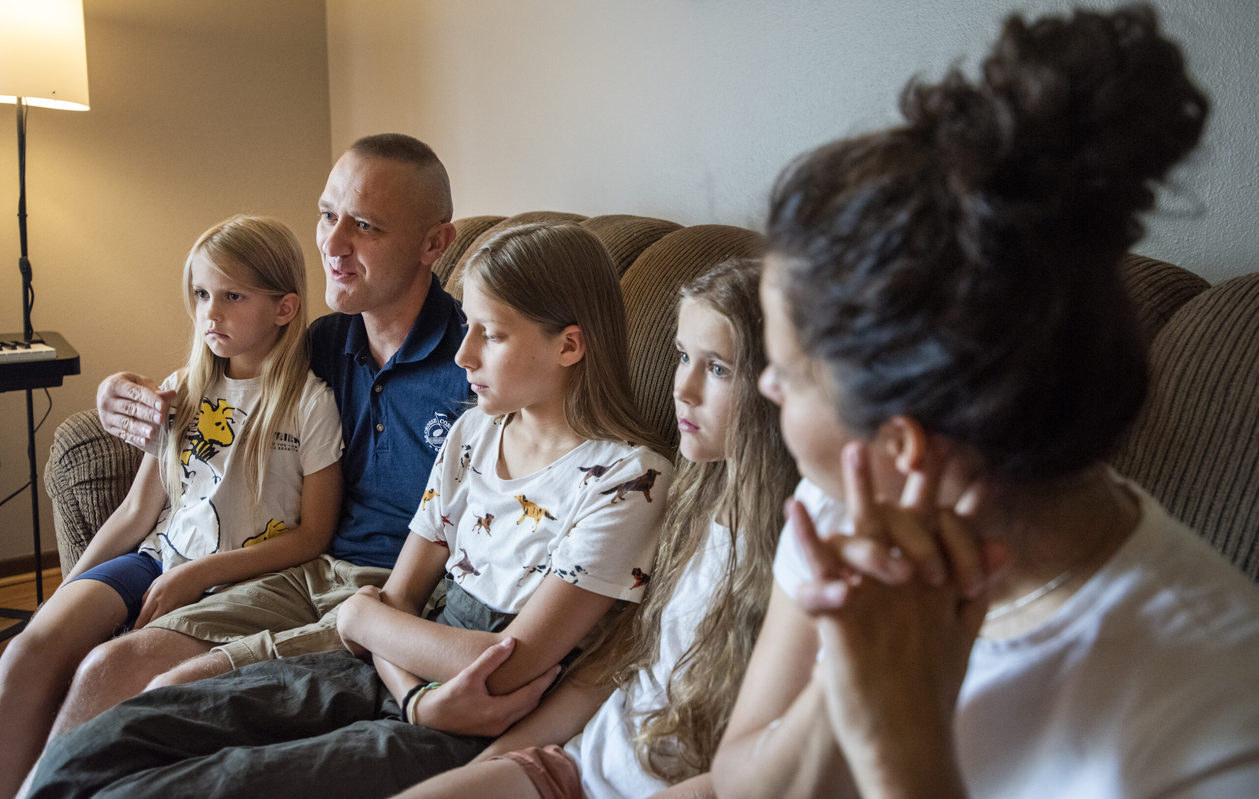 A family sits together on a couch.