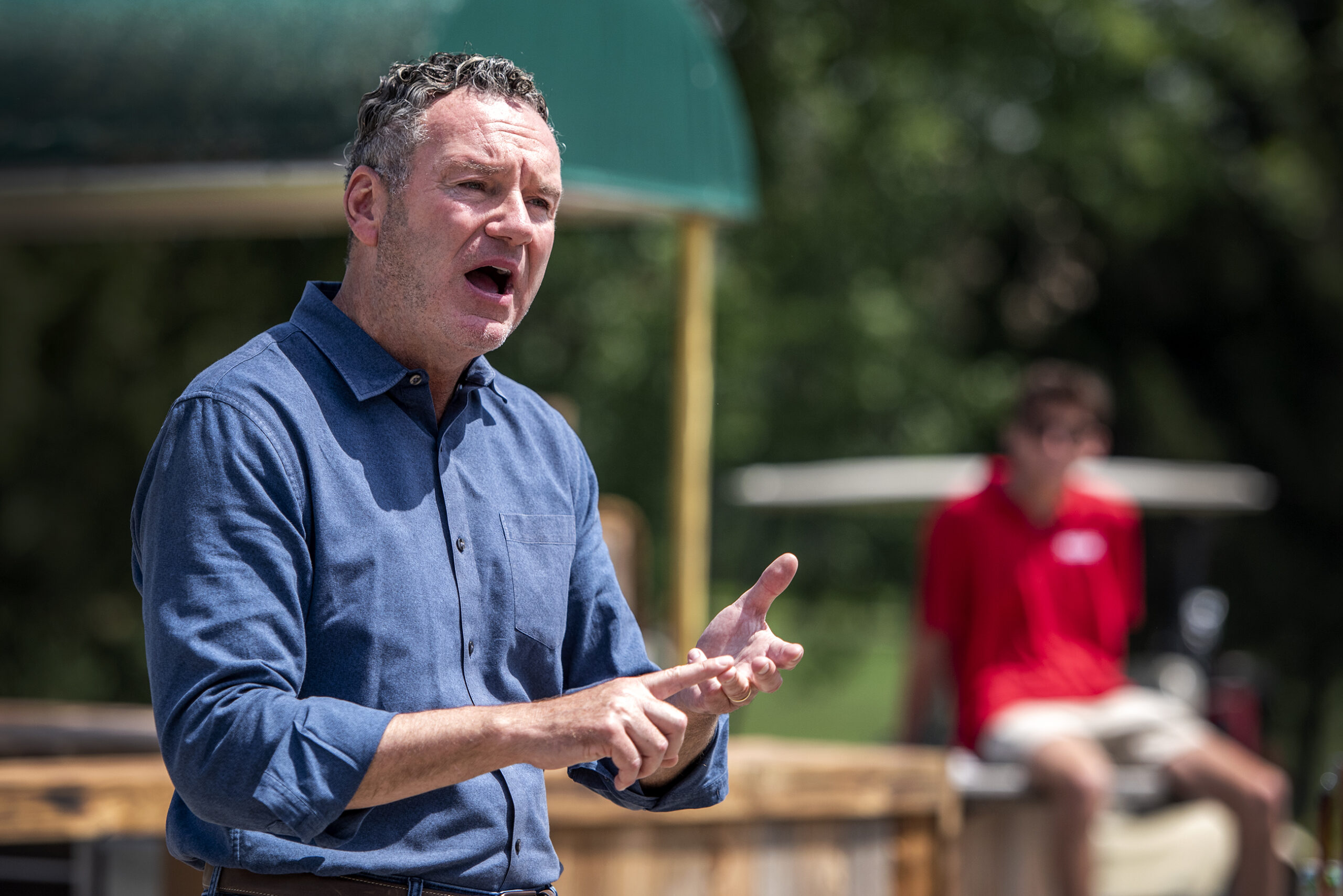 Tim Michels gestures as he speaks outside during an event.