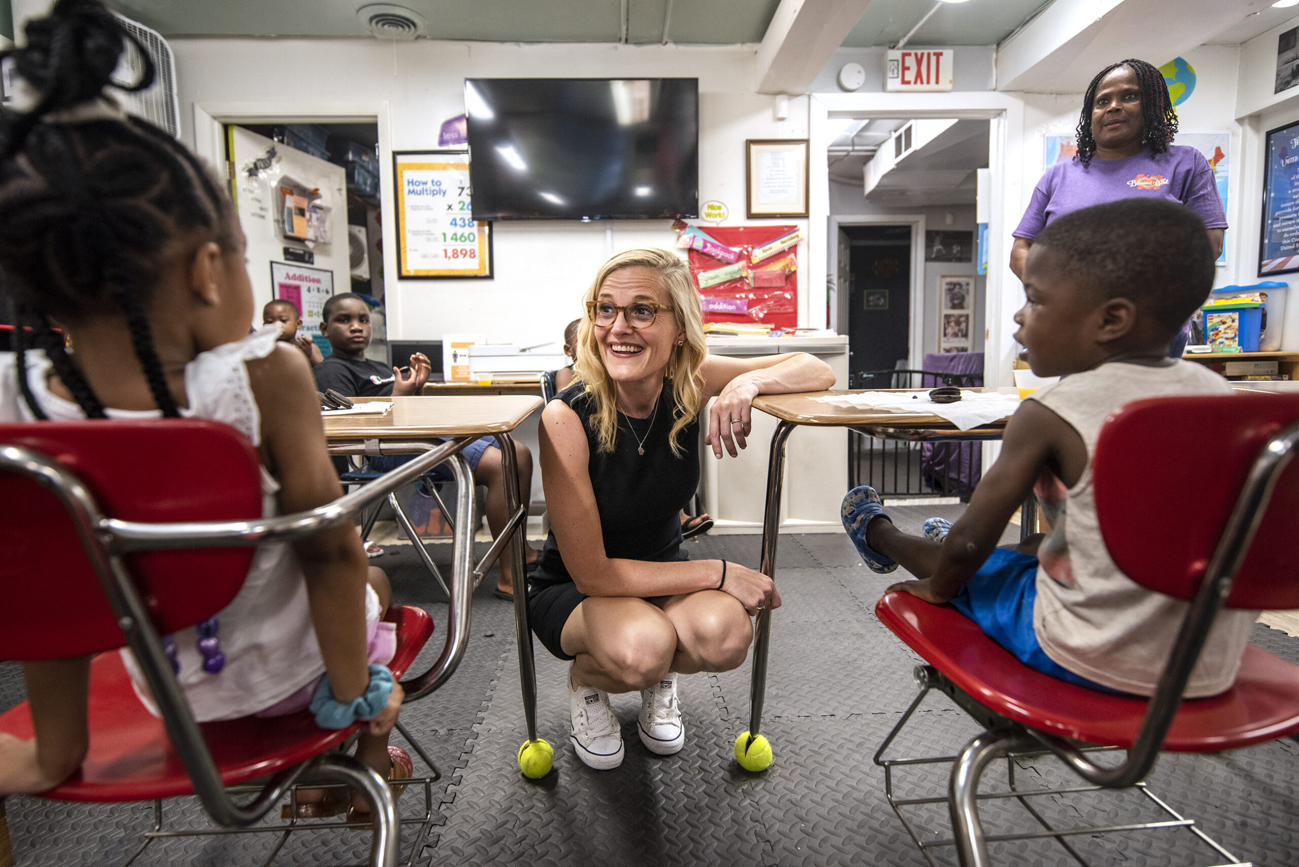Sarah Godlewski smiles as she speaks to young children sitting in desks.