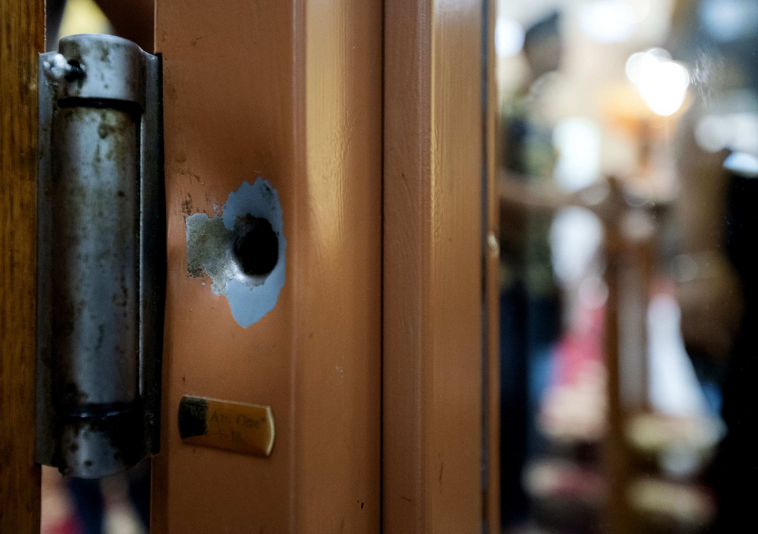 A punctured area on a door frame with a small plaque below.