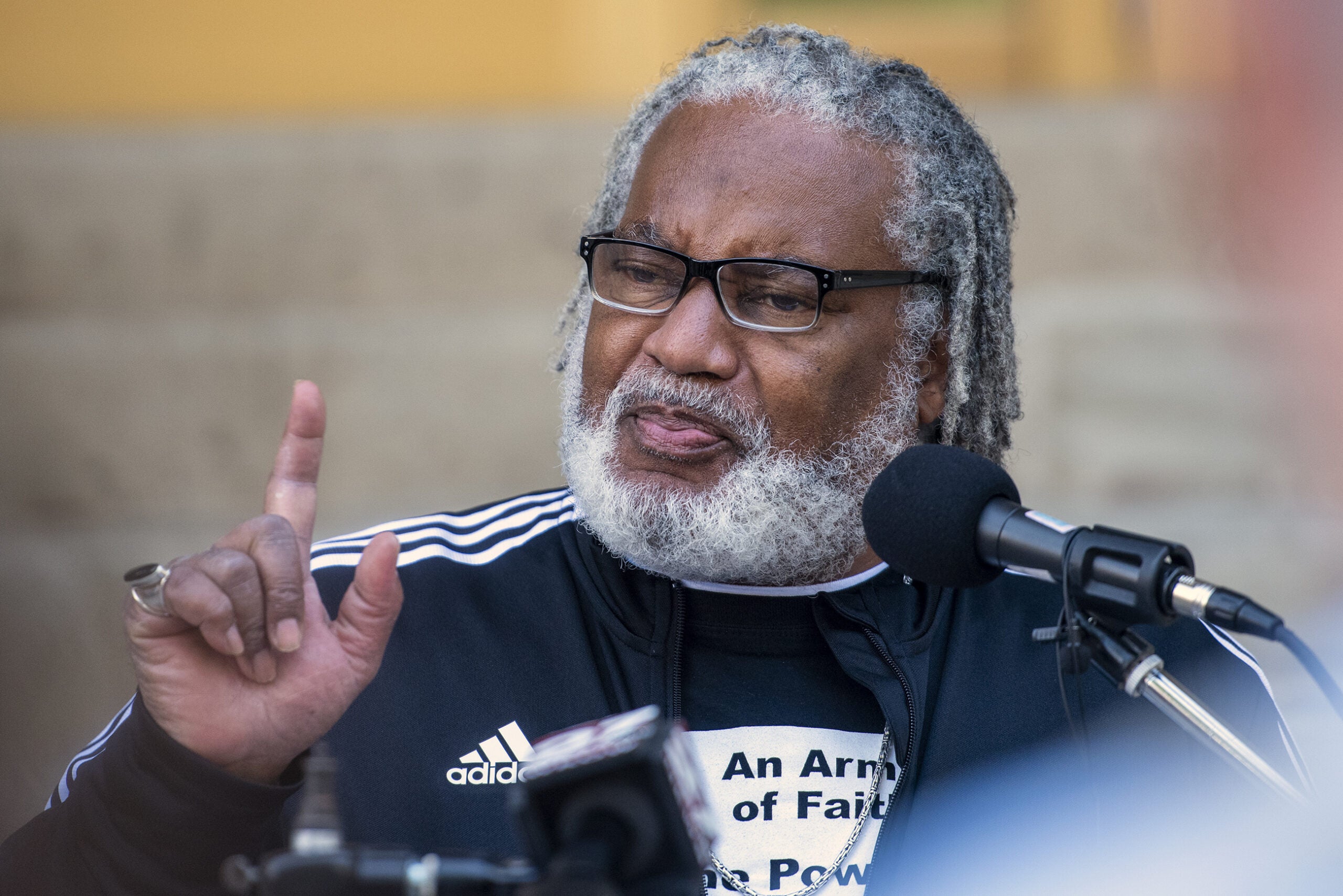 Greg Lewis gestures as he speaks at a podium.