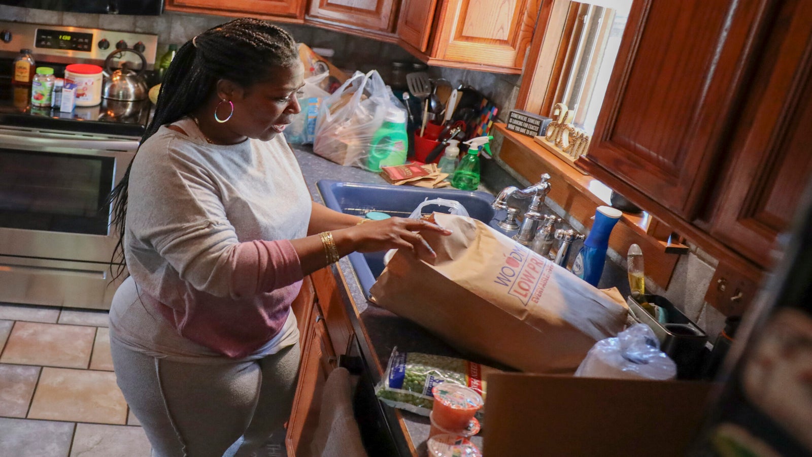 A woman unloads groceries on her kitchen counter