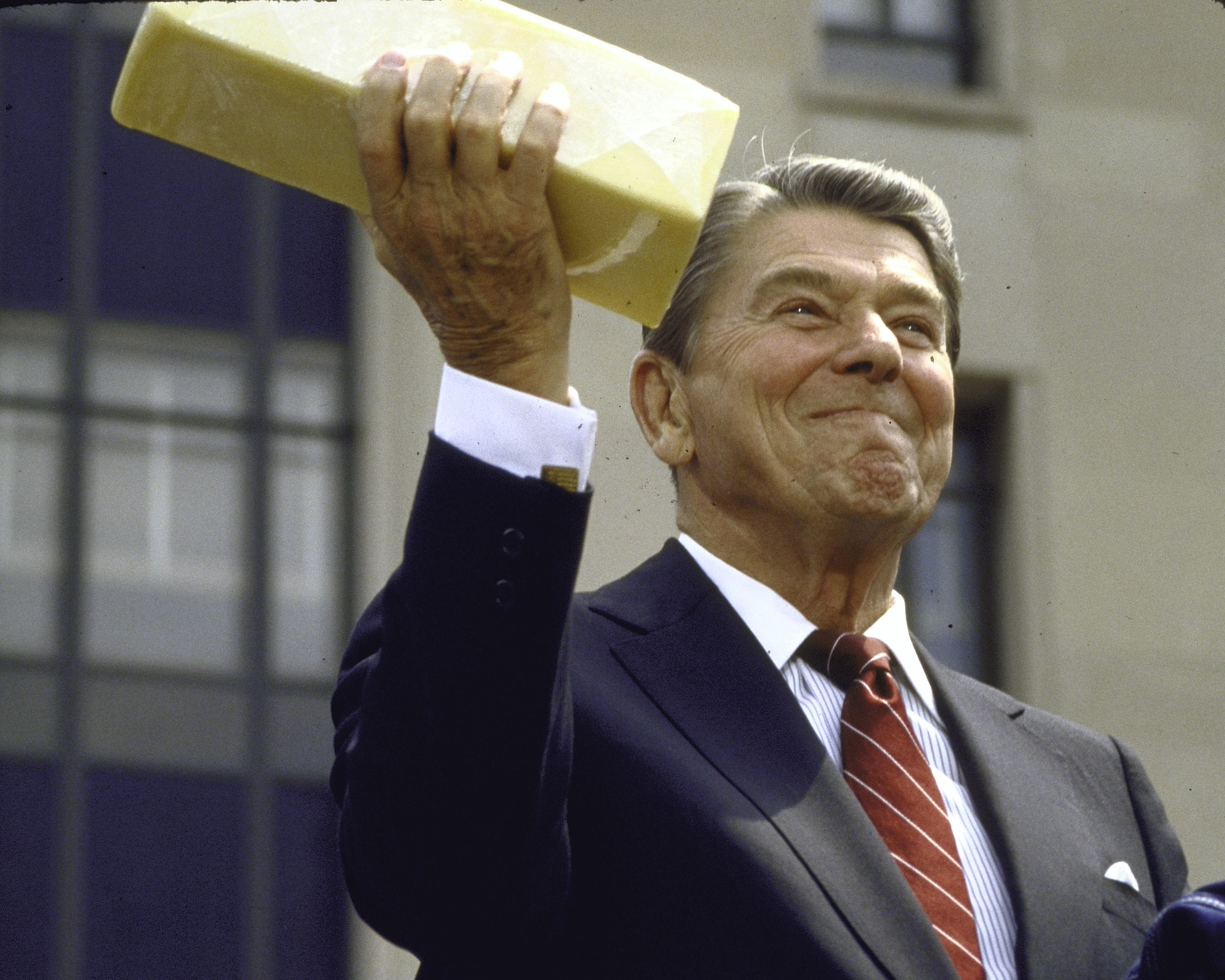 President Ronald Reagan holds up a block of government surplus cheese