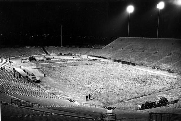 On Dec. 31, 1961 people remove hay on top of tarps from Lambeau Field before a championship game. The hay and tarp kept the field dry