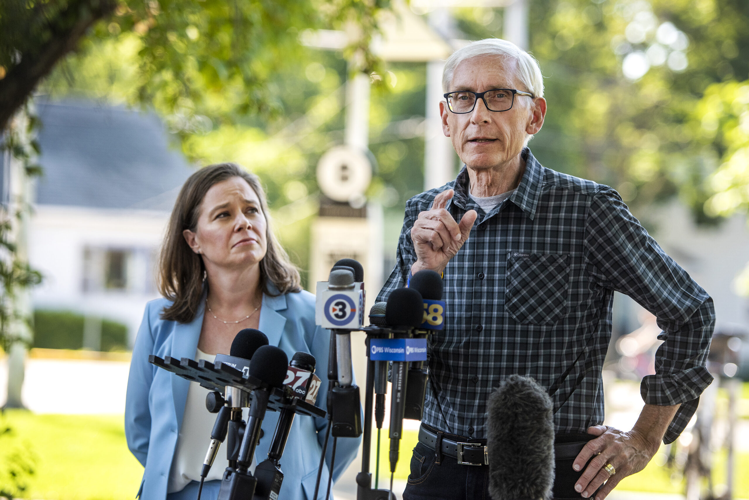 Gov. Tony Evers and Sara Rodriguez stand outside in front of microphones.