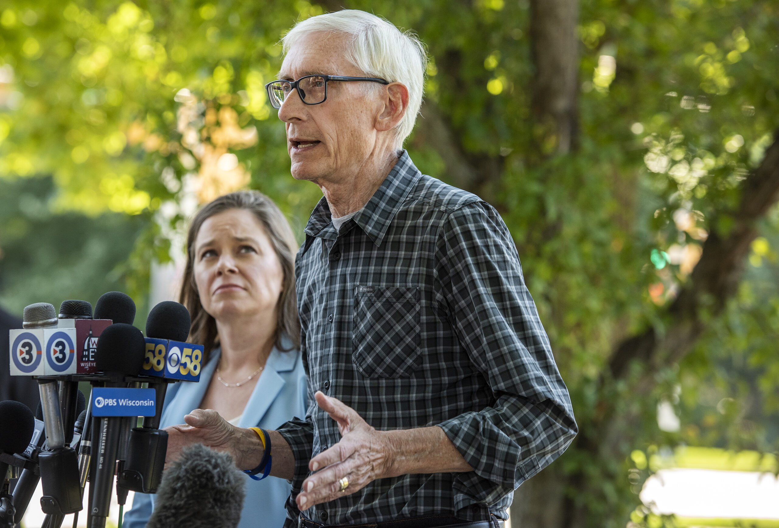 Gov. Tony Evers and Sara Rodriguez speak to reporters outside in front of microphones.